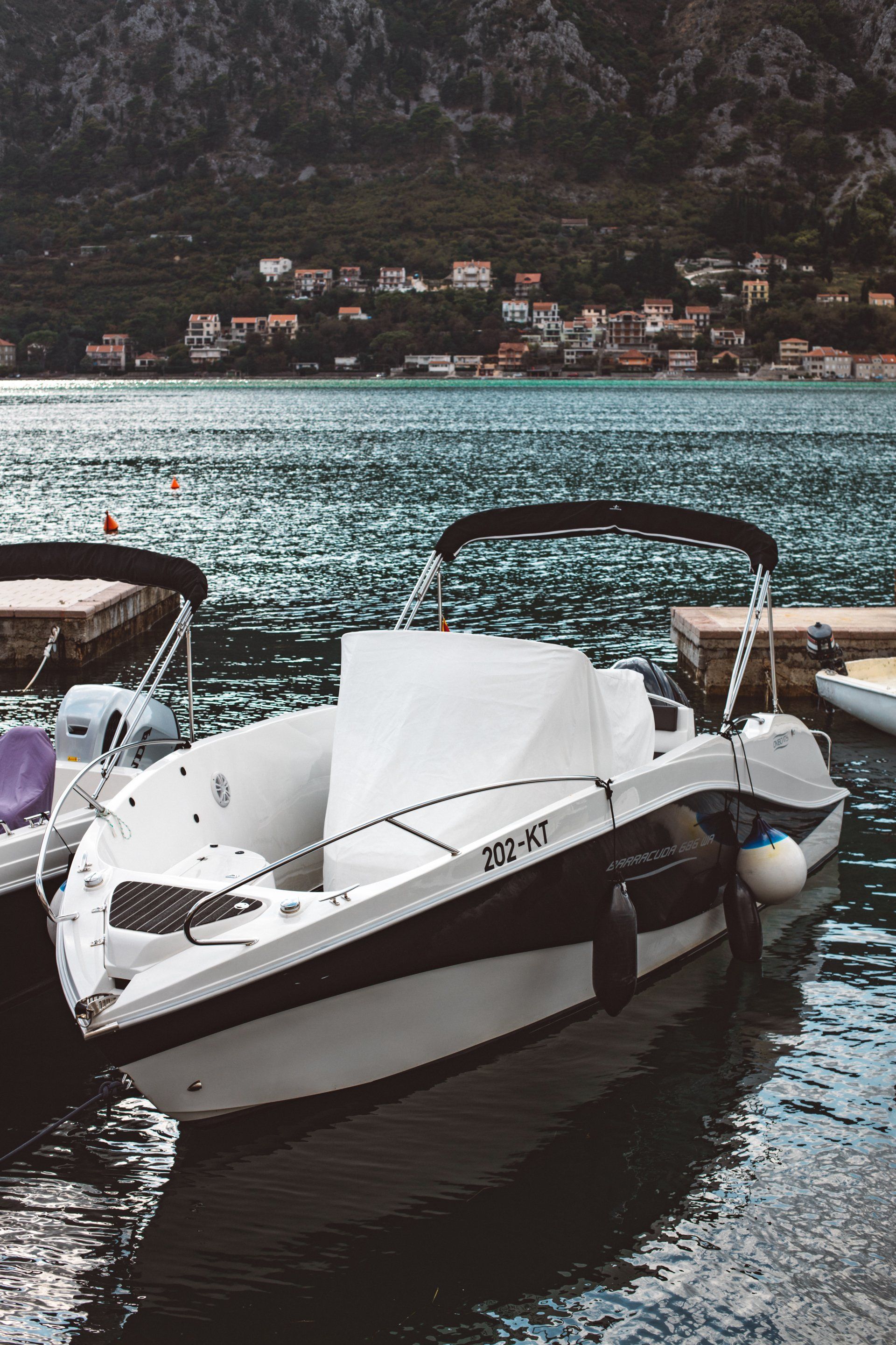 A white boat is docked in the water near a dock.