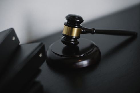 A judge 's gavel is sitting on top of a black table.