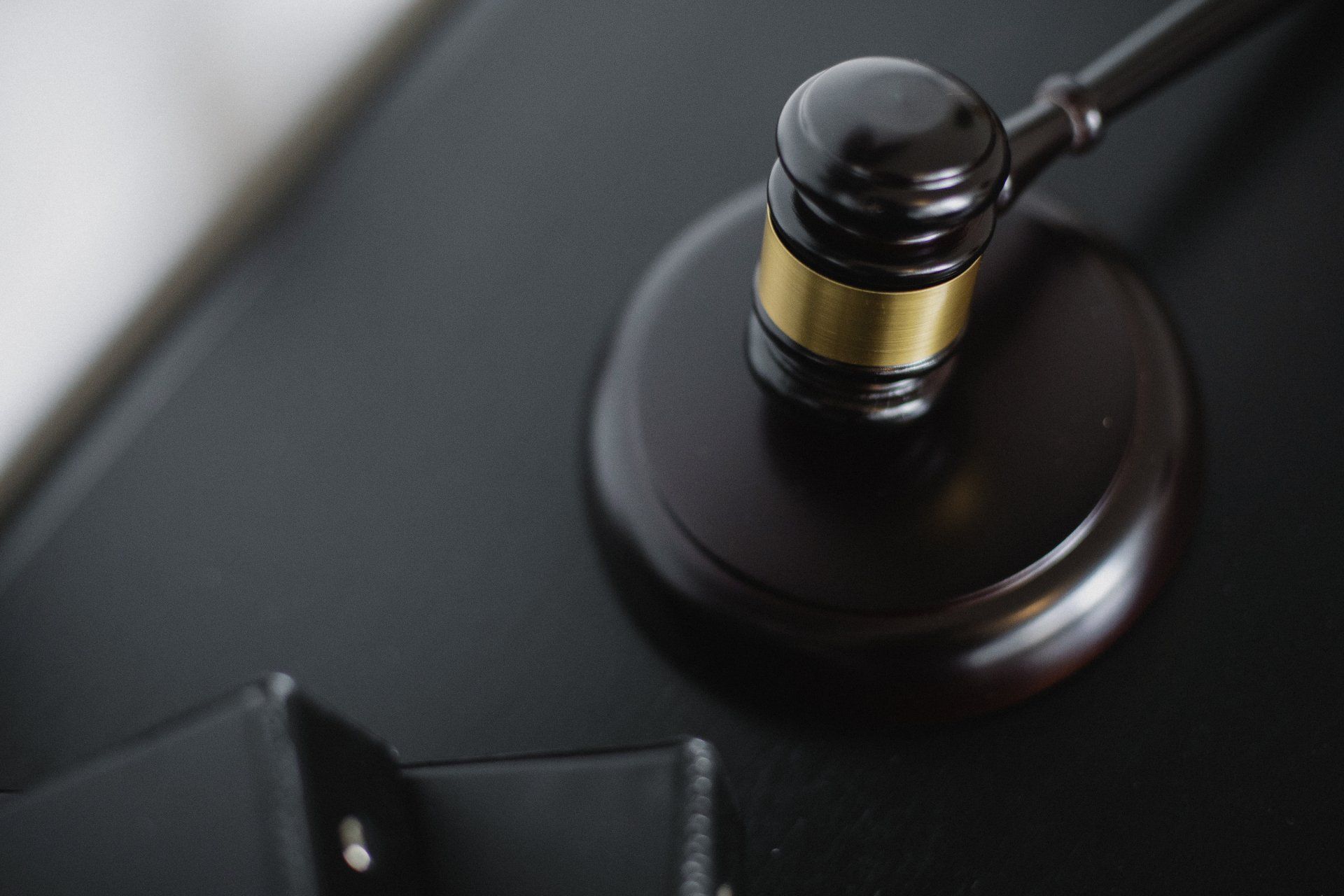 A close up of a judge 's gavel on a black table.