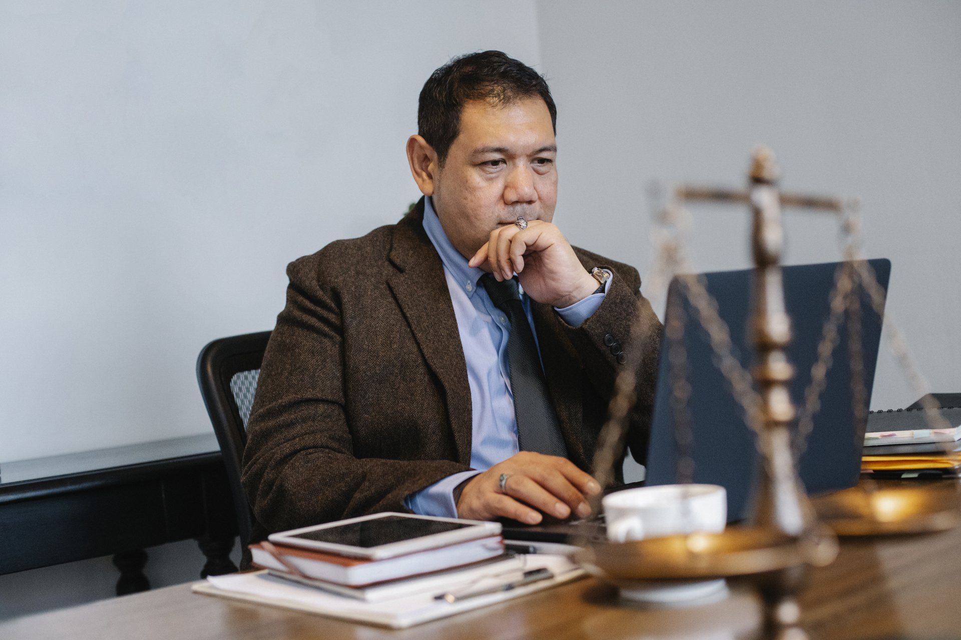 a man is sitting at a desk using a laptop computer .