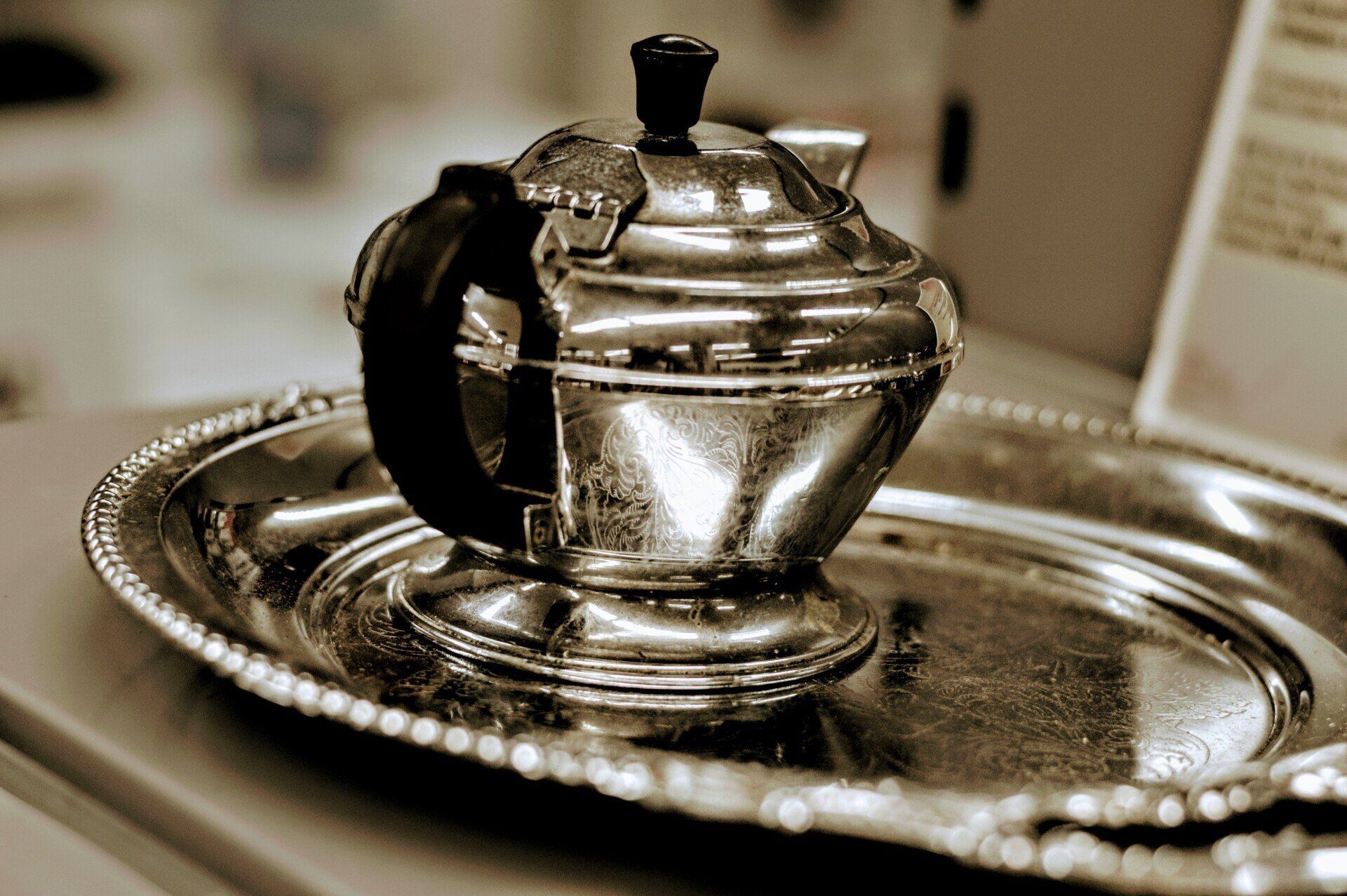 A silver teapot is sitting on a silver tray