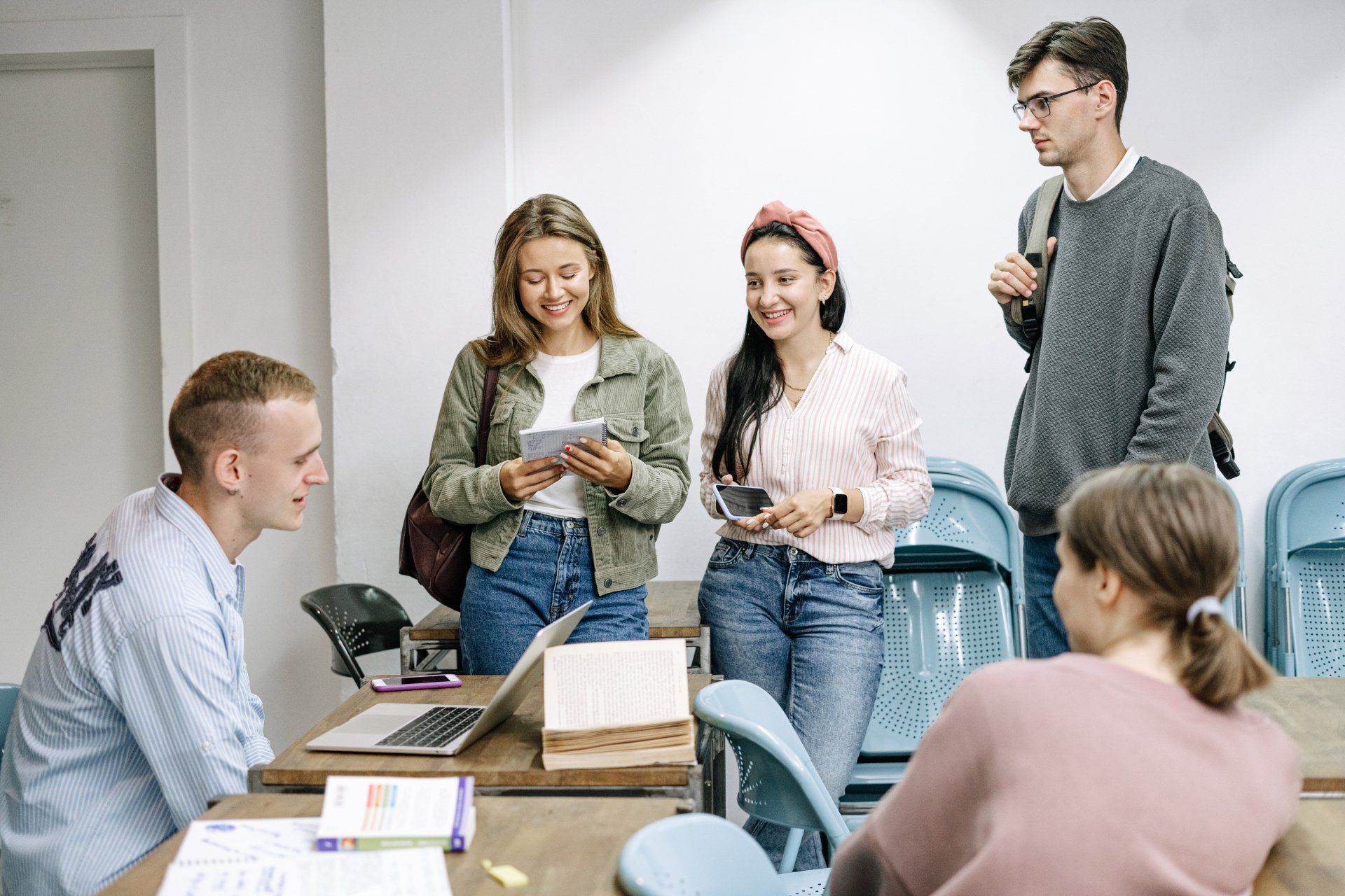 A group of young people are standing around a table in a classroom.