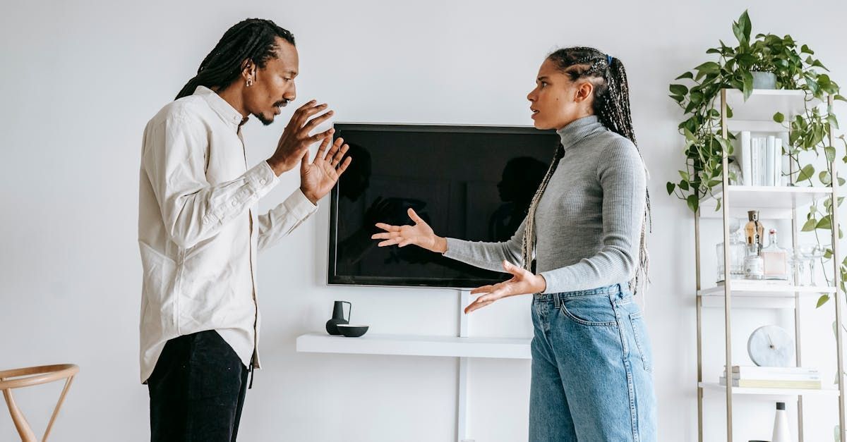 A man and a woman are having an argument in front of a television in a living room.