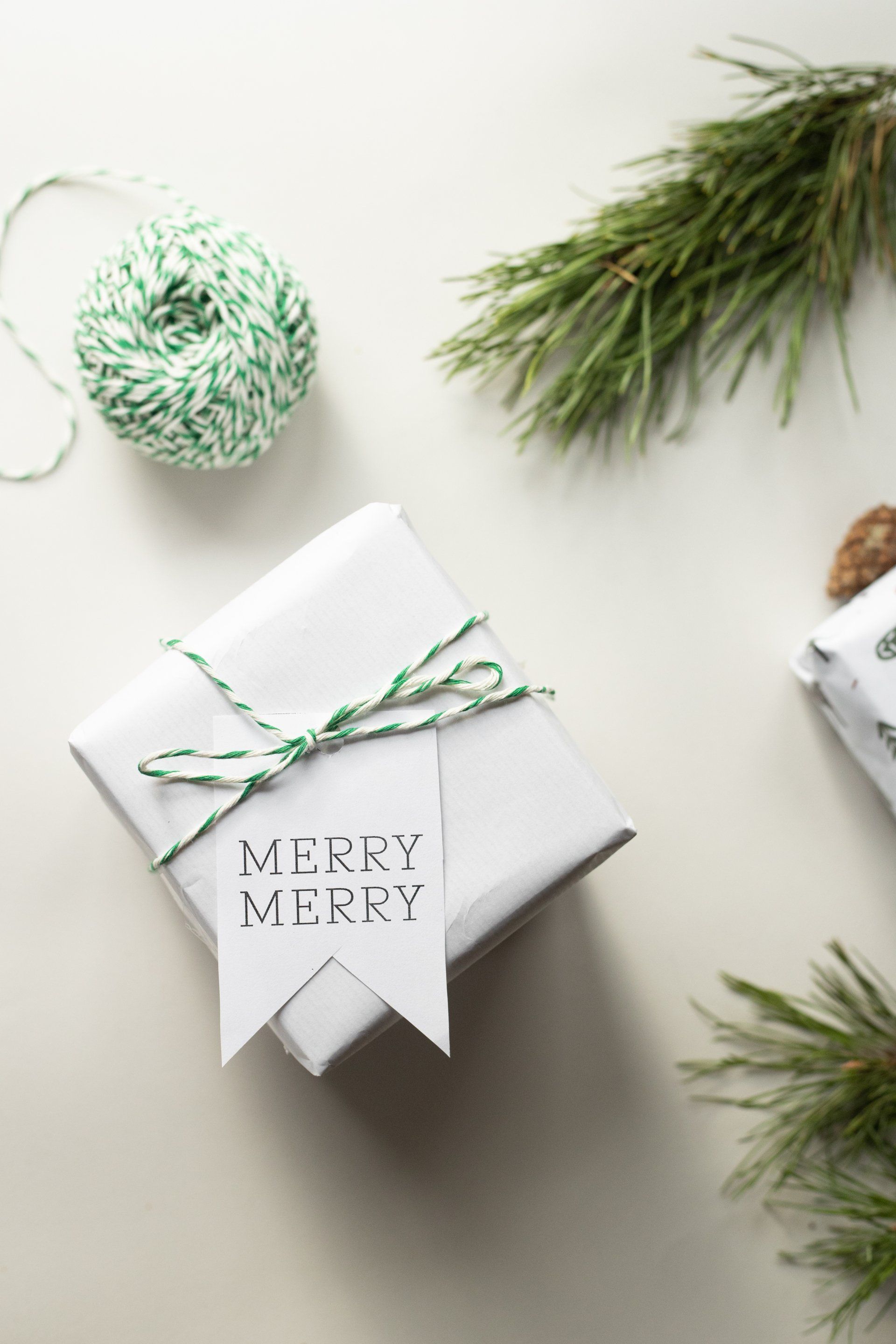 A gift wrapped in white paper with a merry merry tag on it.