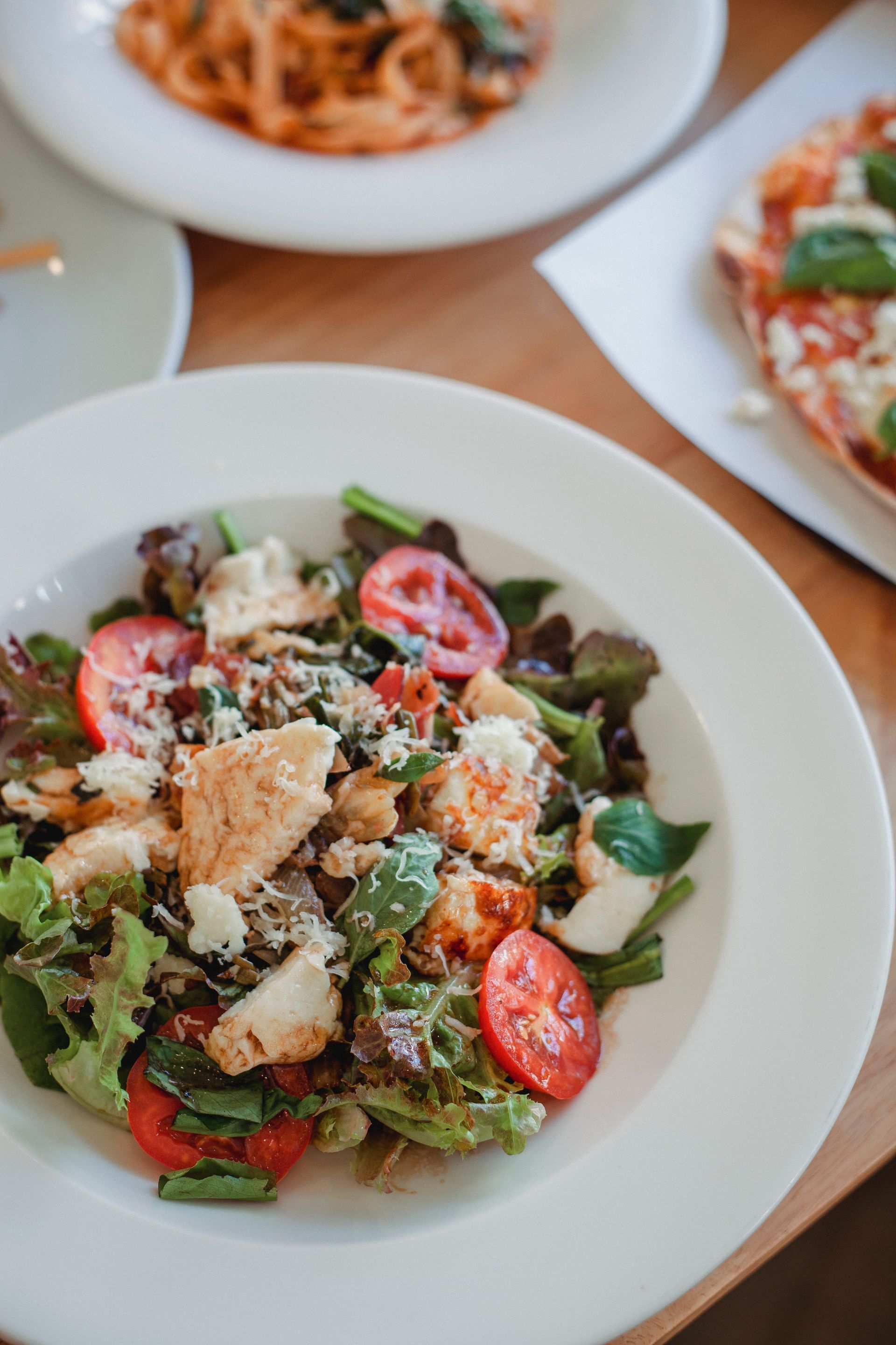 A close up of a salad on a plate on a table.
