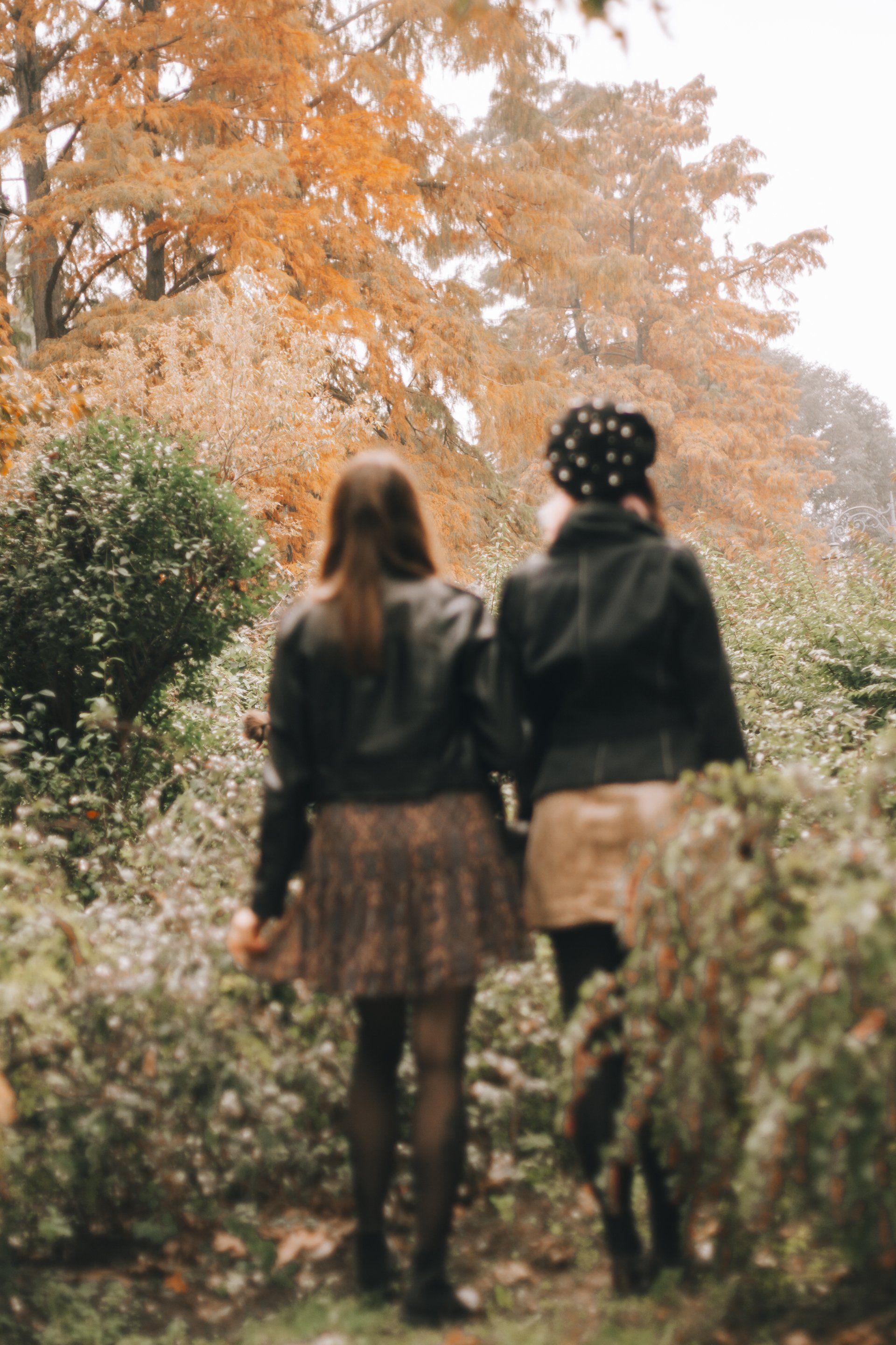 2 women walking dressed in Autumn clothes