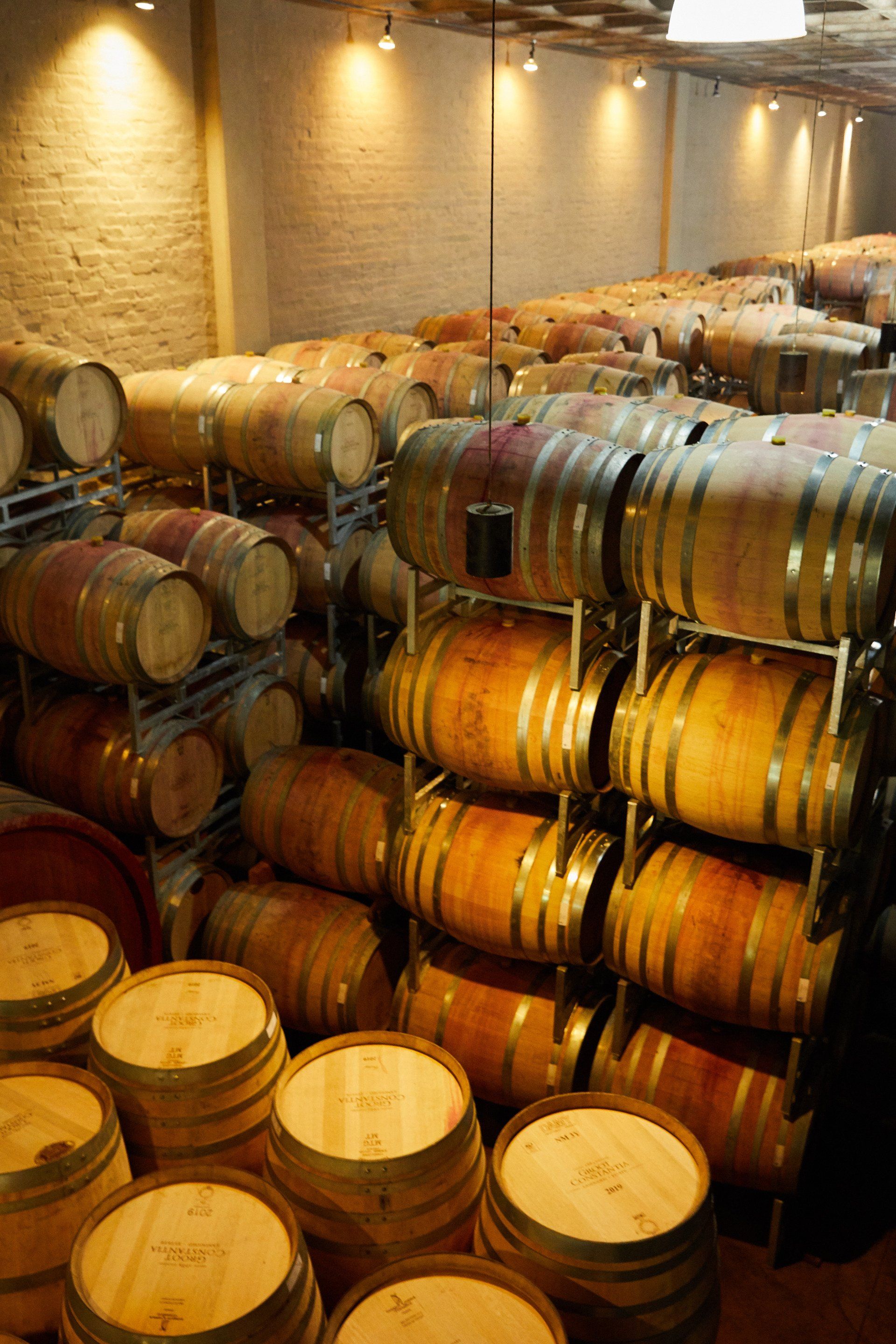 A bunch of wine barrels are stacked on top of each other