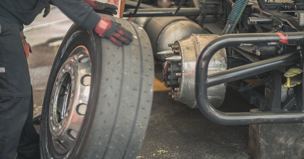 A man is changing a tire on a truck.
