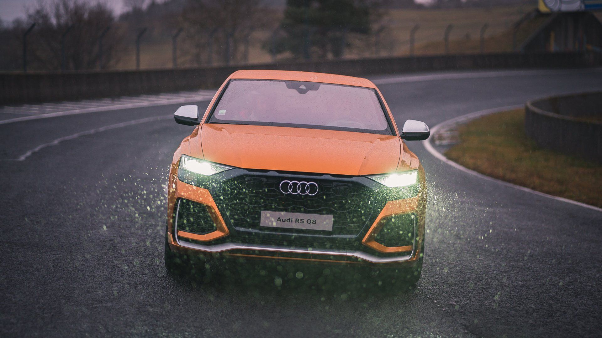 Orange Audi RS Q8 driving in the rain