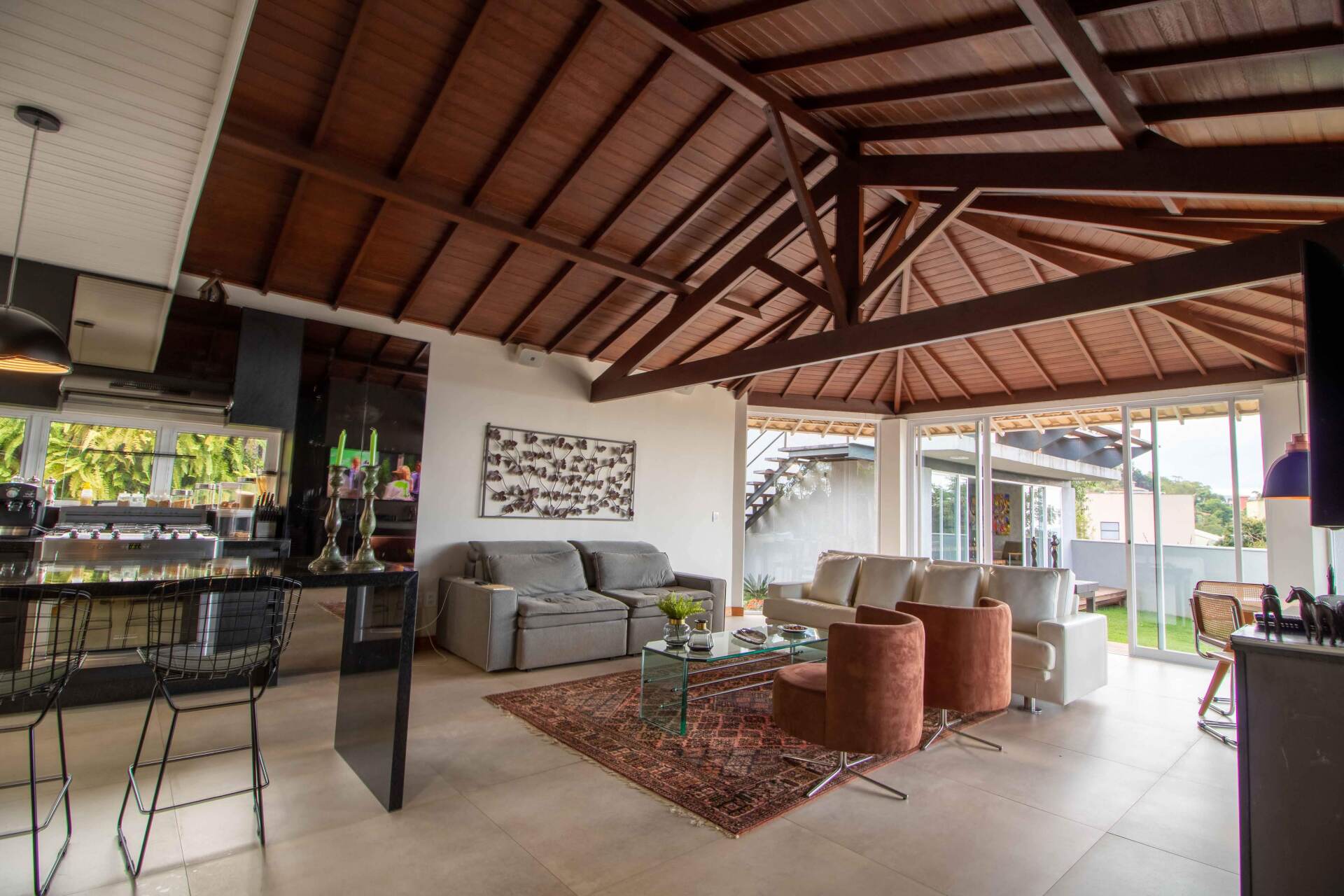 A living room with a wooden ceiling and a couch and chairs