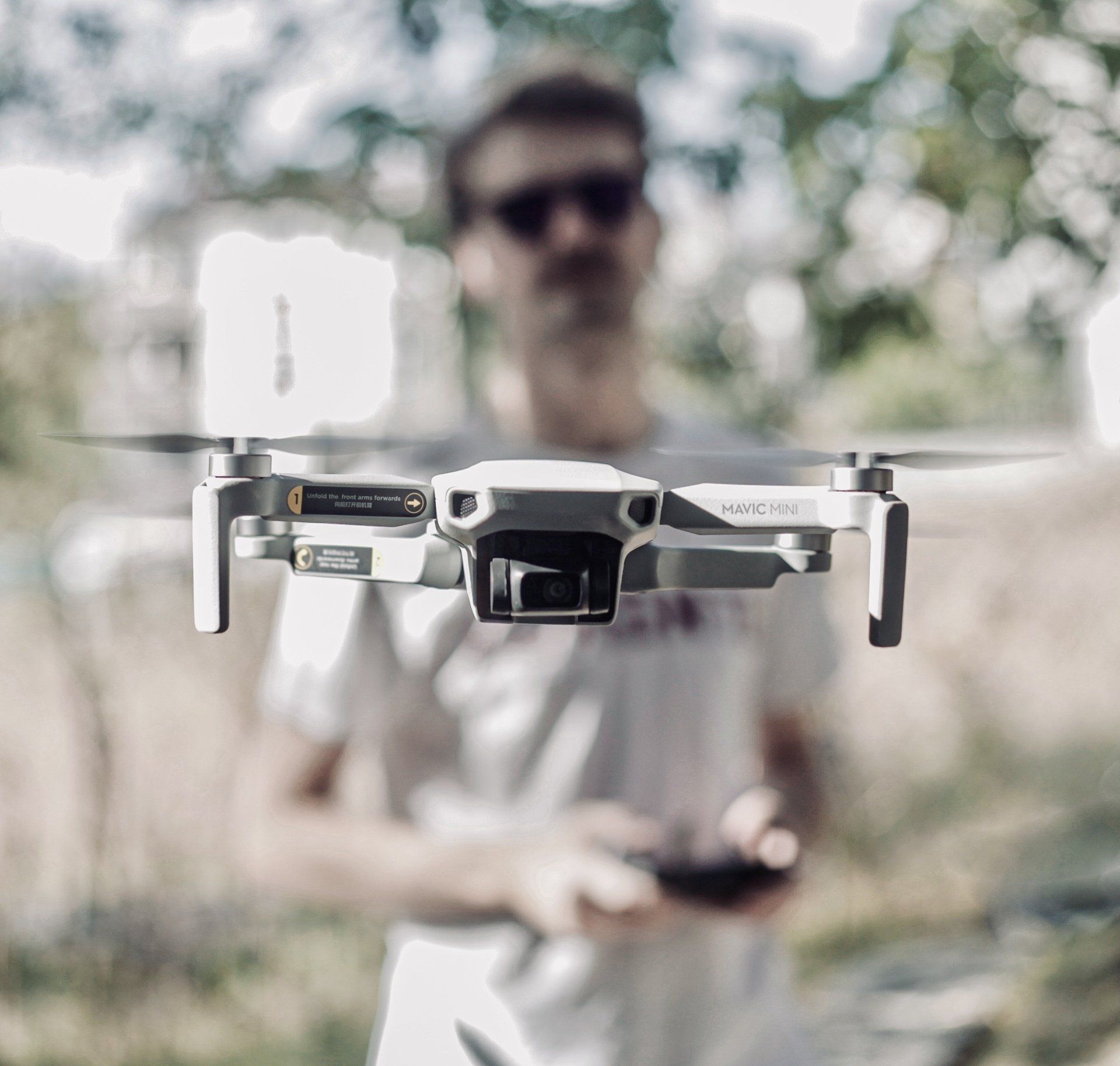 A man is holding a remote control and flying a drone.