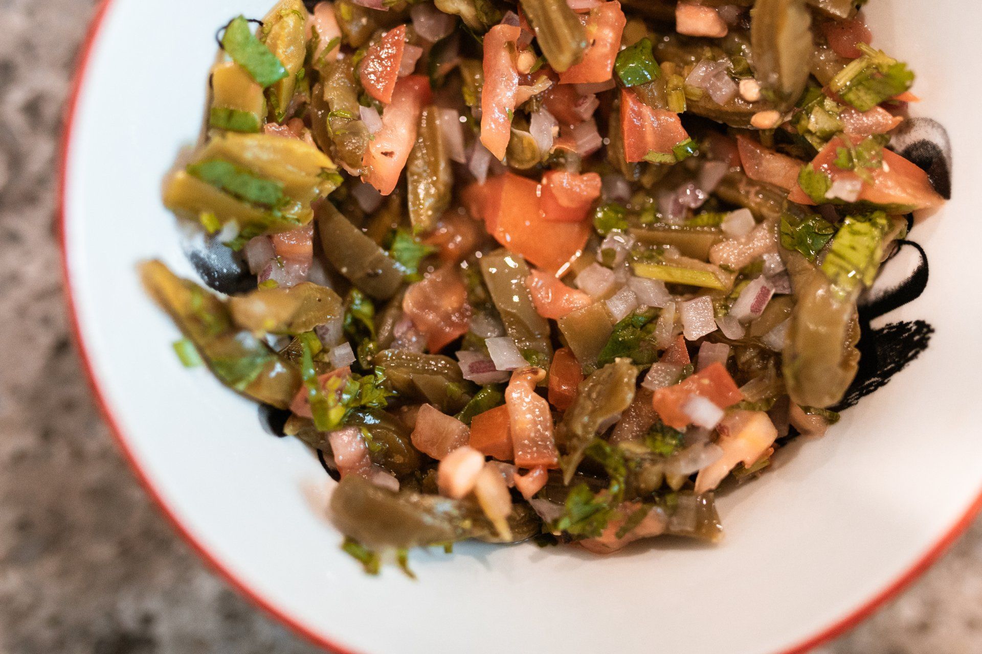 A close up of a bowl of vegetables on a table.