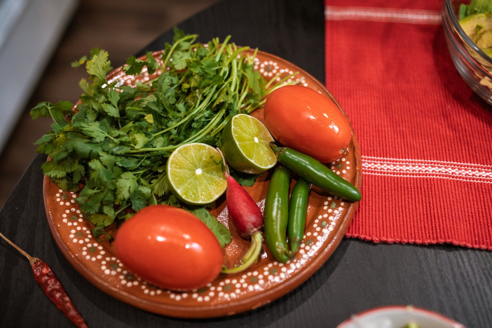 A plate of vegetables and herbs on a table.