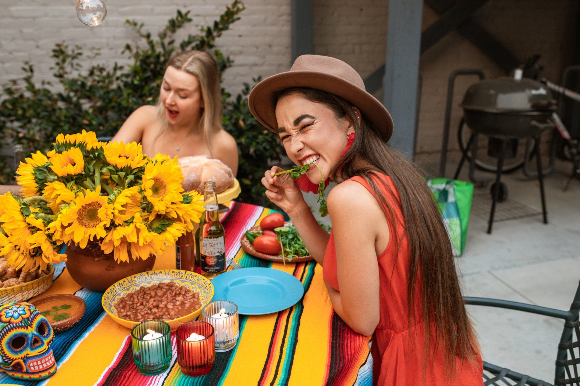 Two women are sitting at a table eating mexican food.