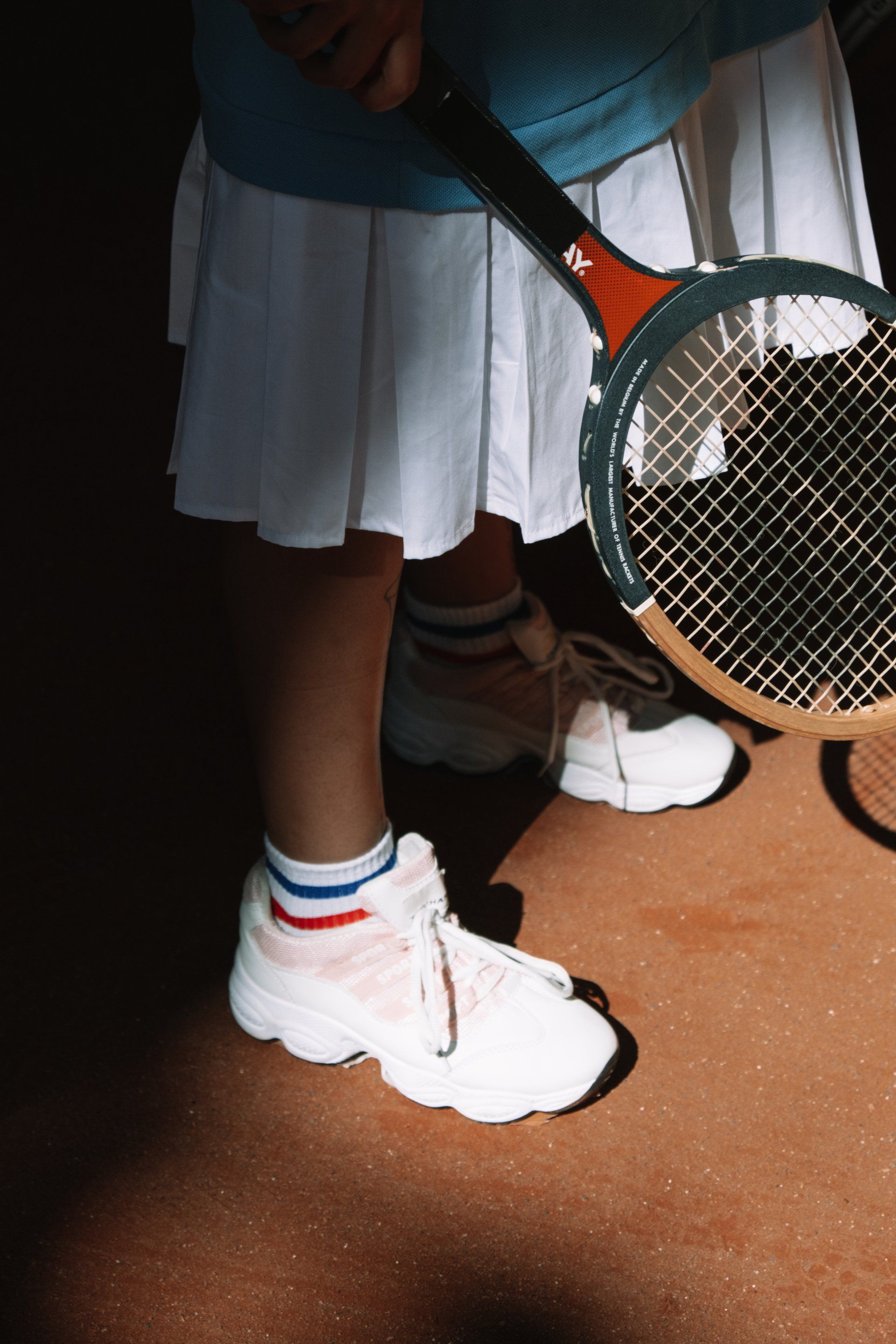 Young woman's feet showing that she's holding a tennis racket