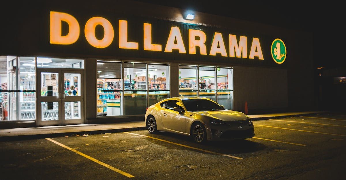 An EV car is parked in front of a dollarama store at night.
