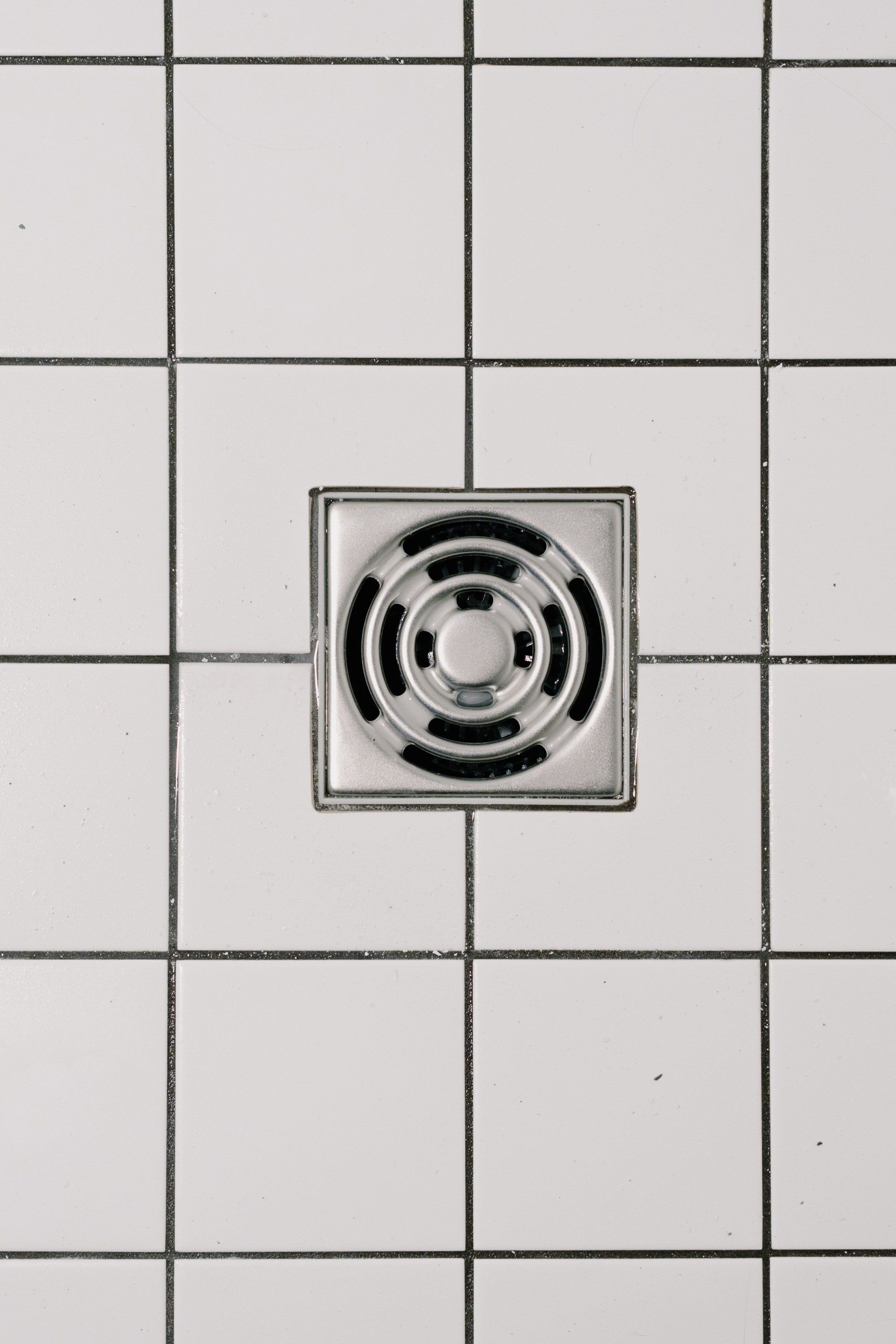 a close up of a drain on a tiled floor .