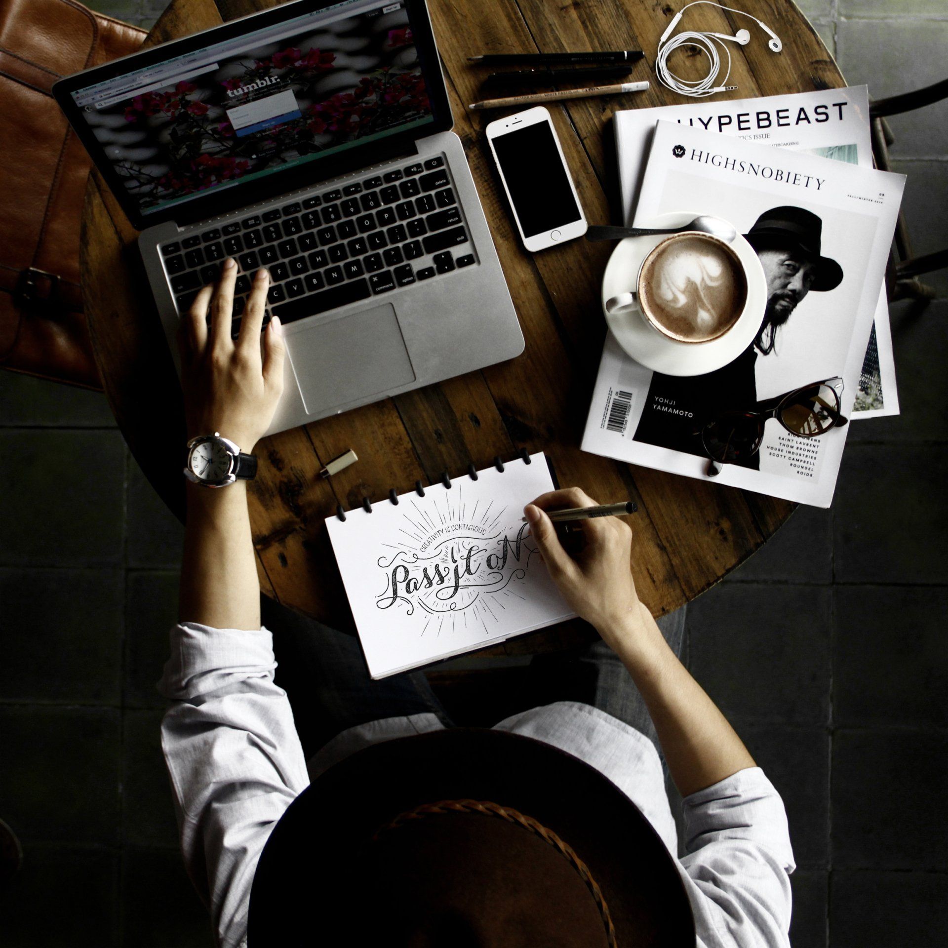 A person is sitting at a table with a laptop and a cup of coffee.