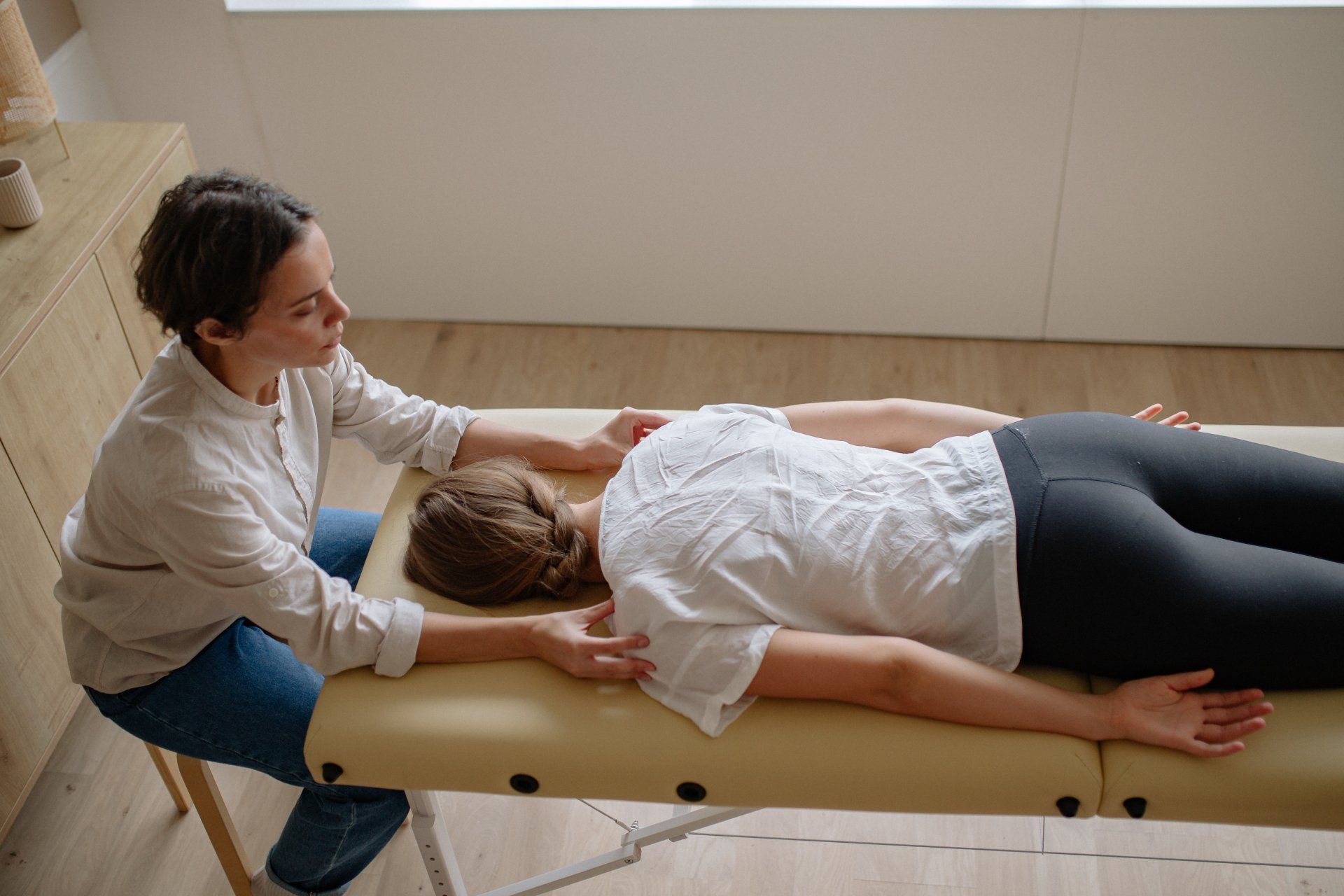Chiropractor examining patient on adjusting table
