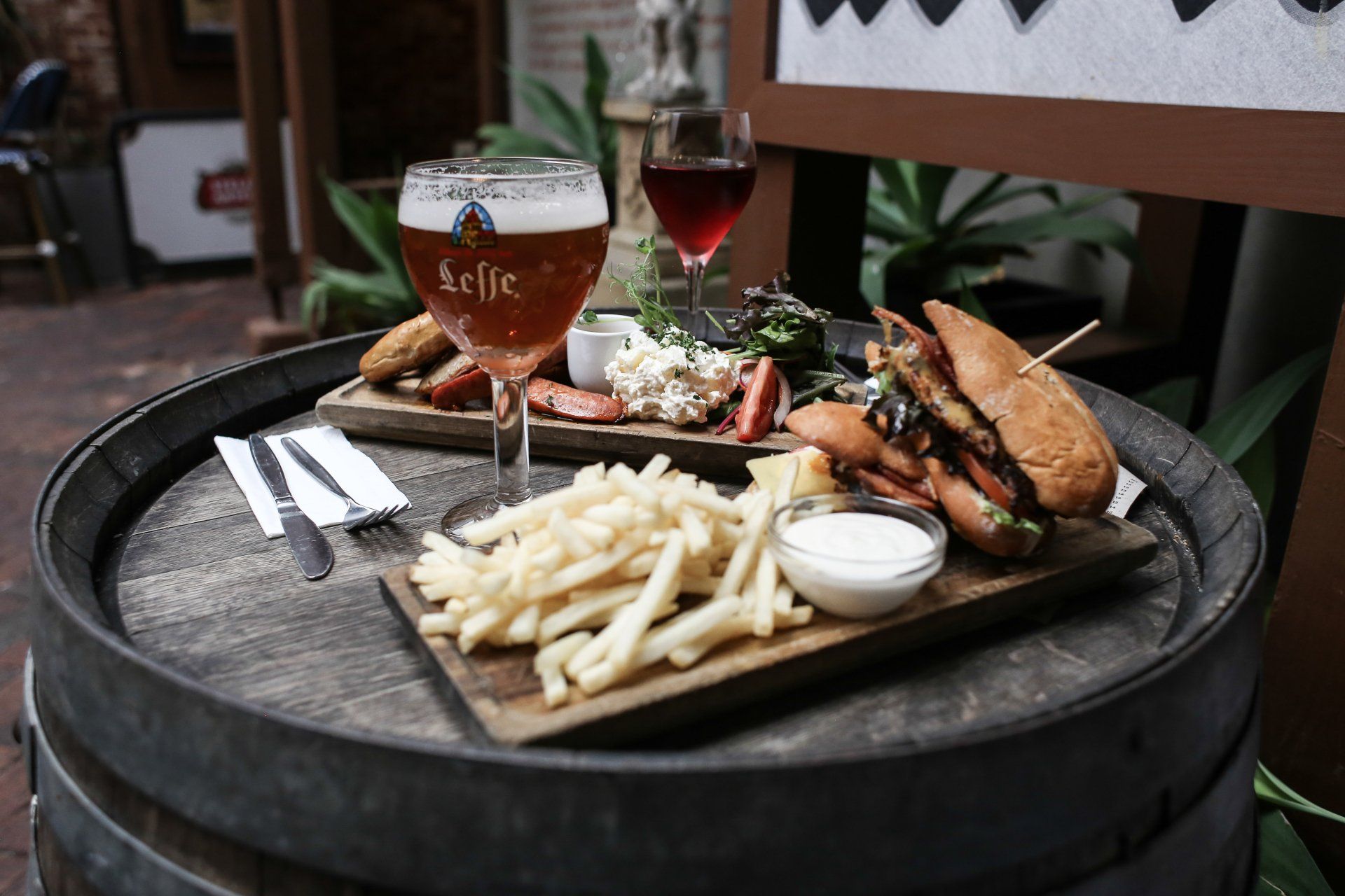 A wooden barrel with a plate of food and a glass of beer on it.