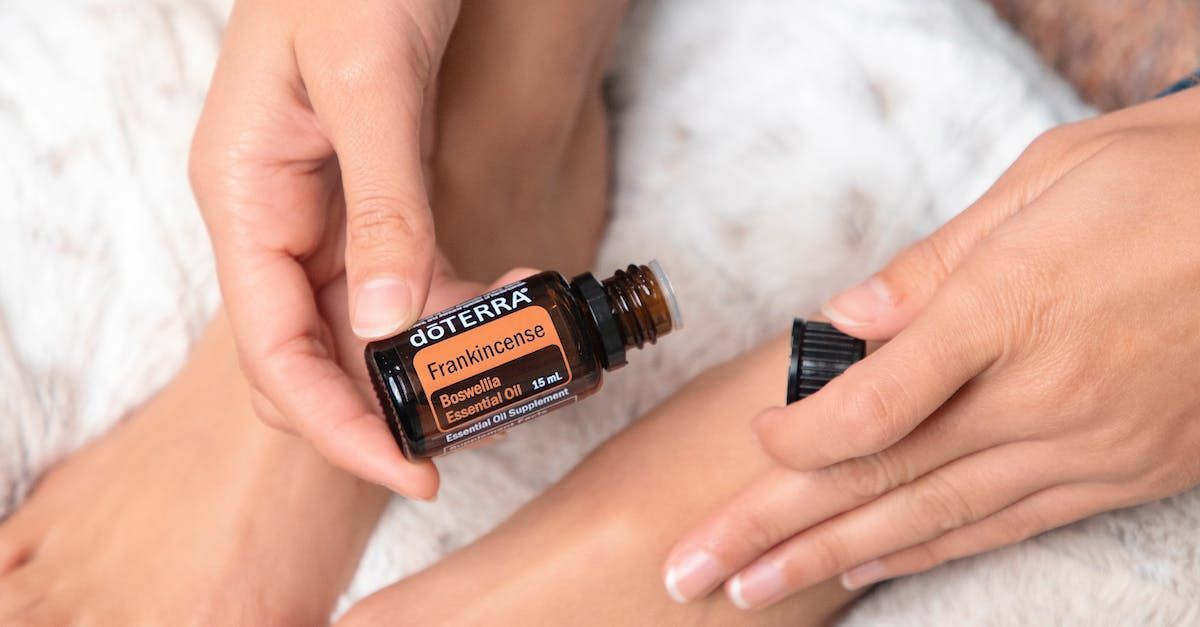 a person is pouring essential oil into another person 's foot .