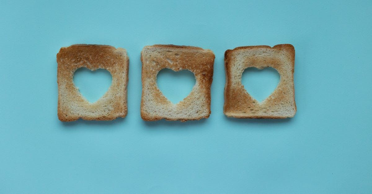 tre pezzi di pane tostato con fori a forma di cuore su sfondo blu .
