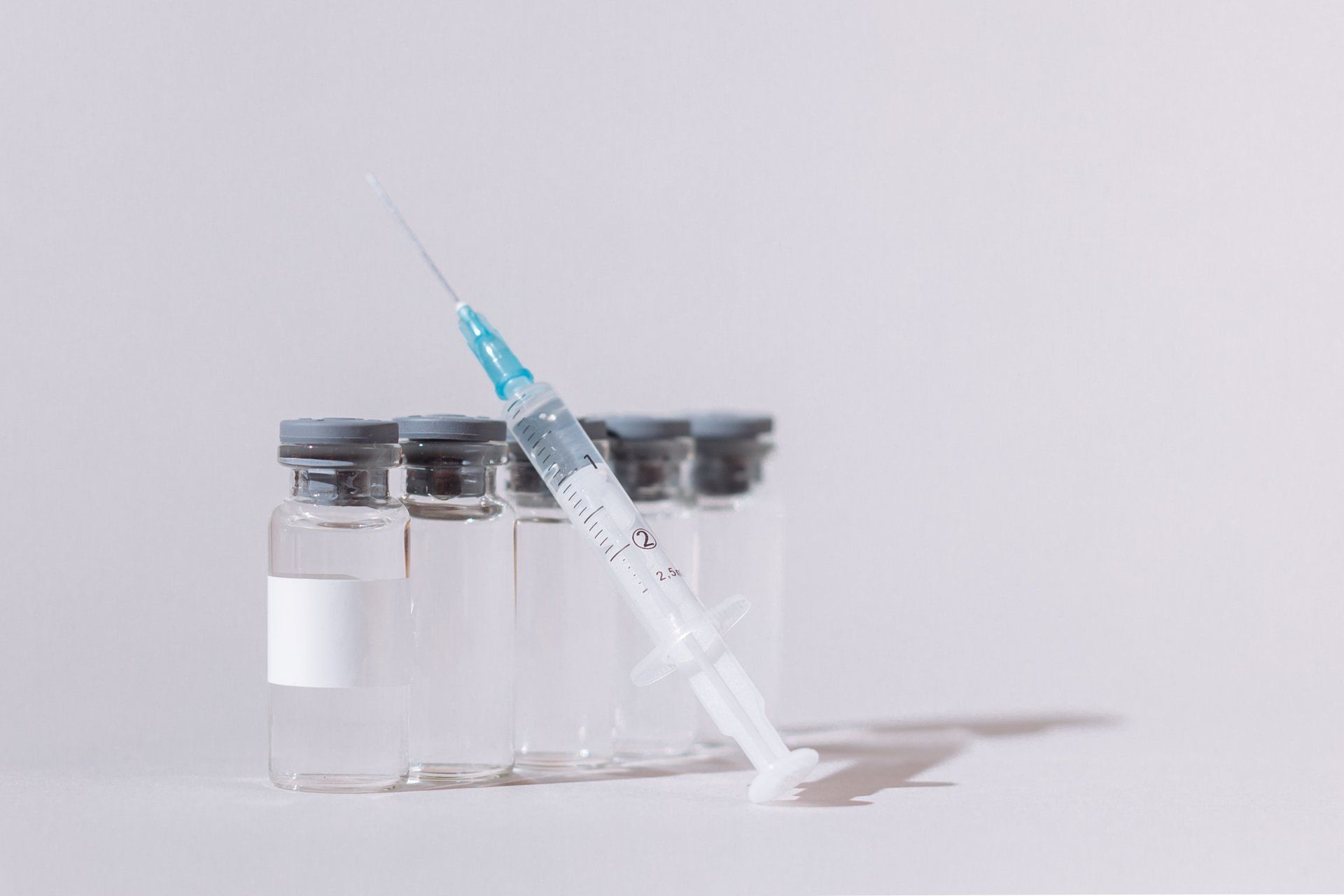 Vaccine leaning against vaccine vials