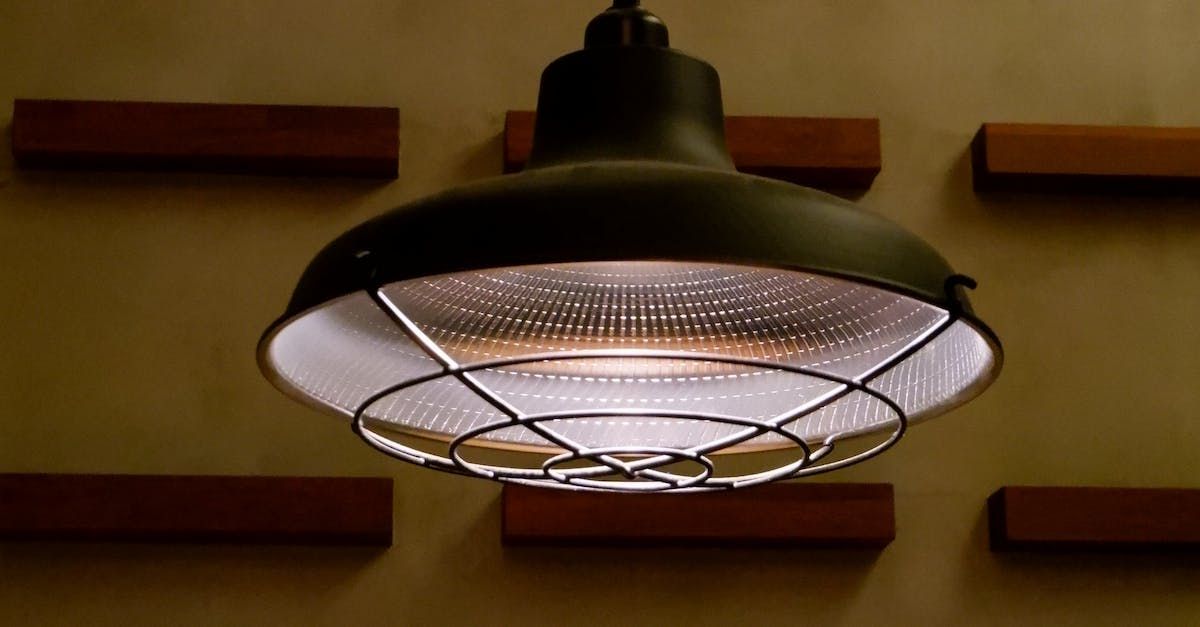 a light hanging from the ceiling with a cage around it