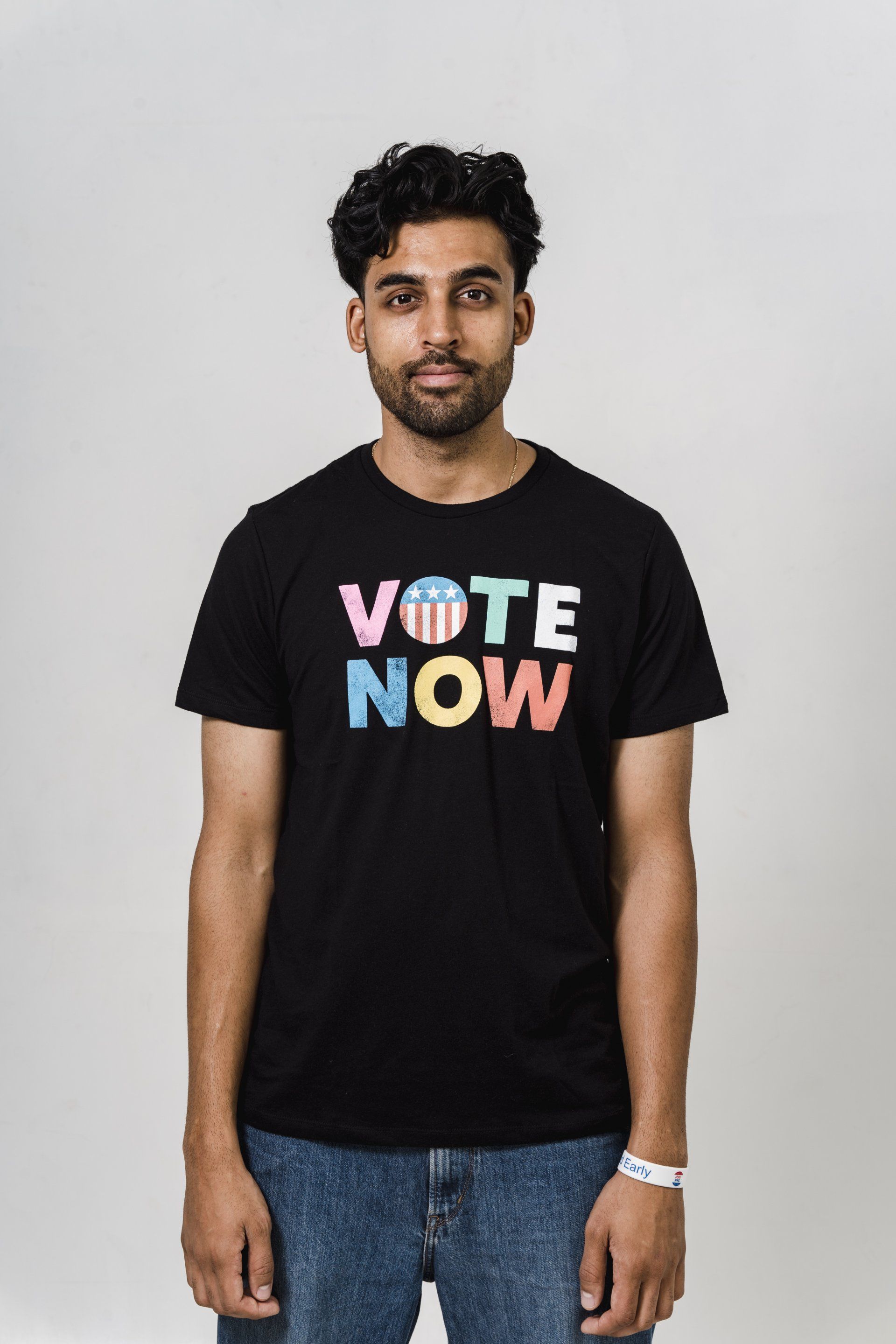 Um homem está vestindo uma camiseta preta que diz vote agora.