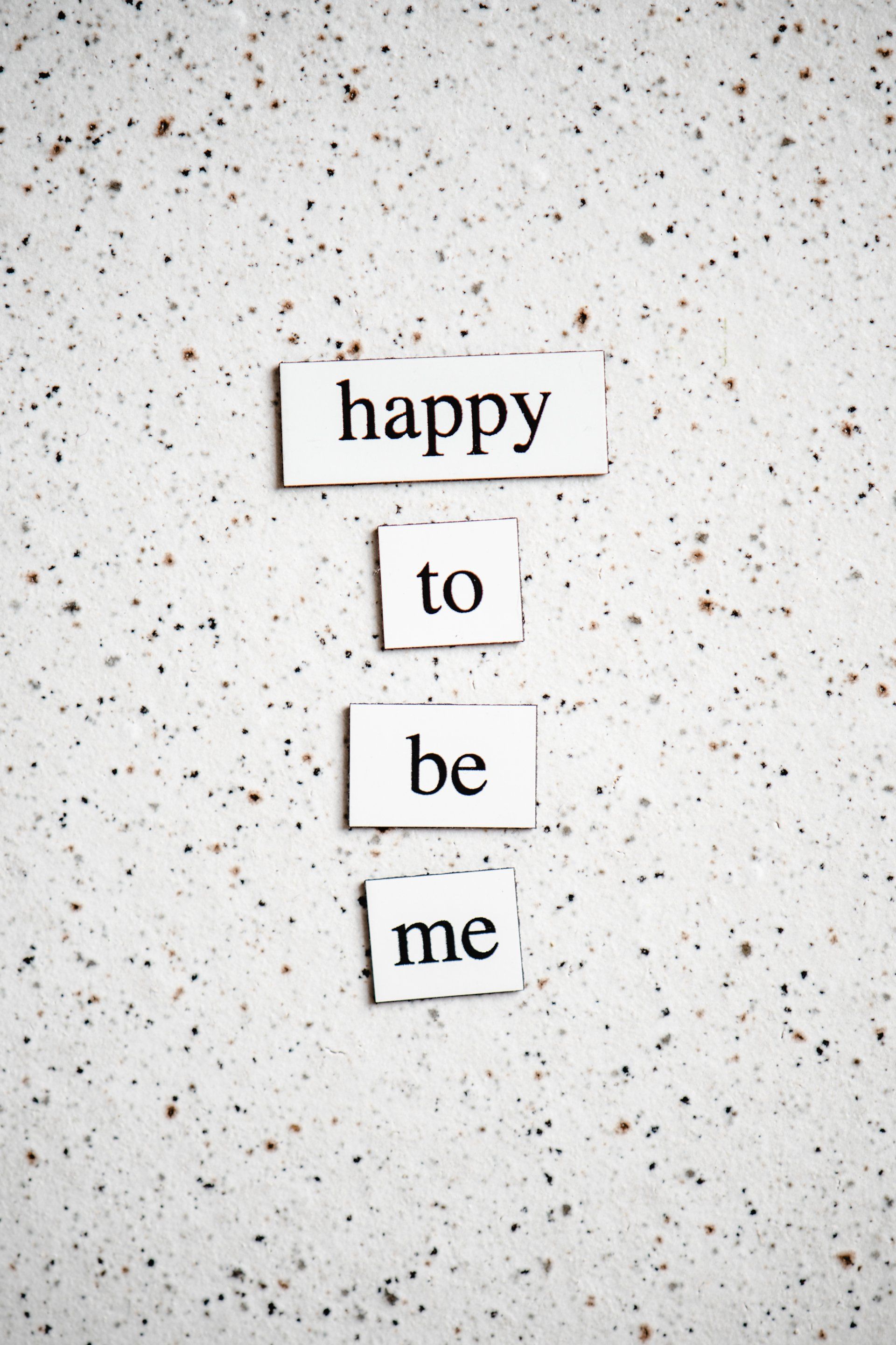 The words happy to be me are written on a piece of paper