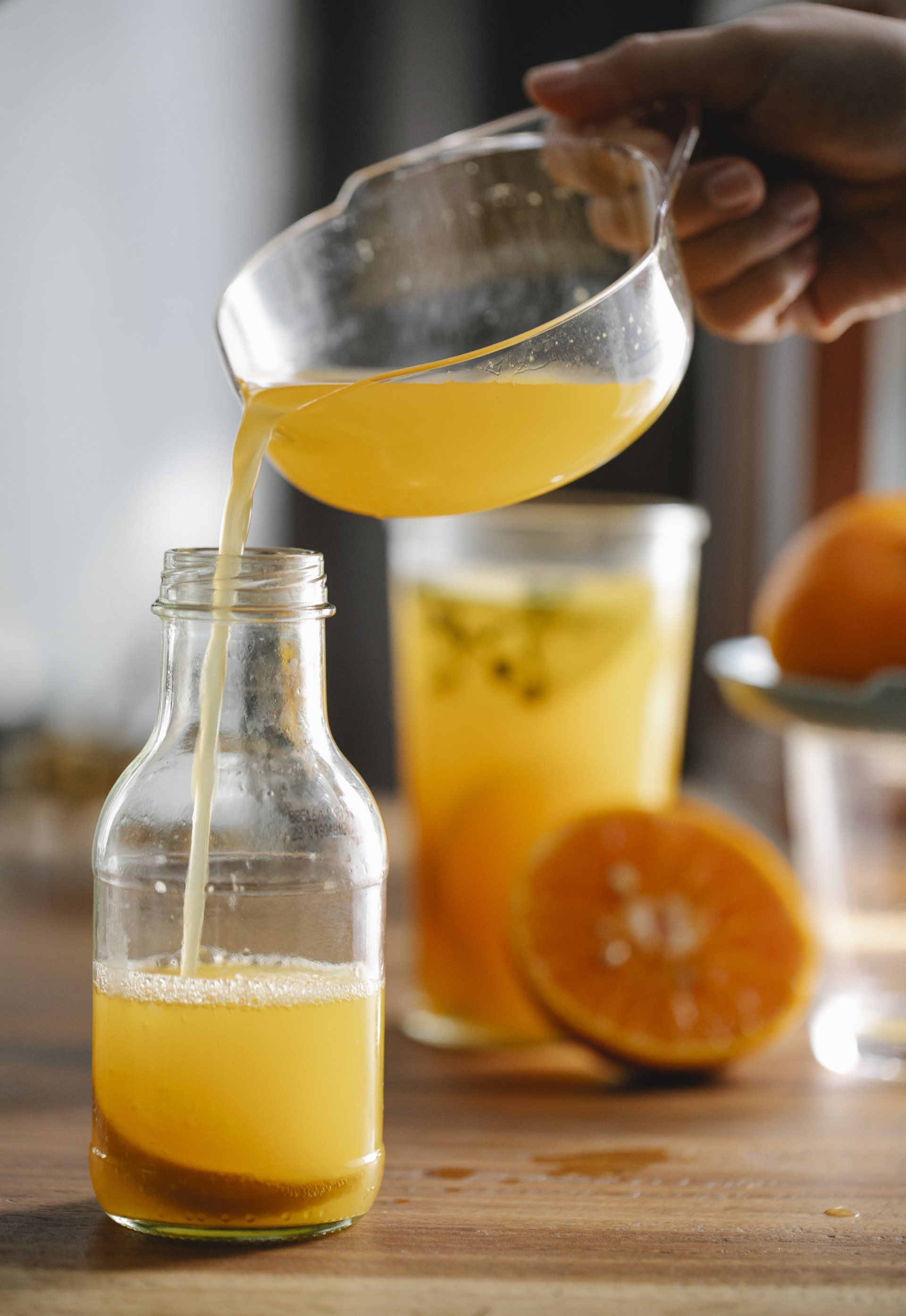 une personne verse du jus d' orange dans un verre