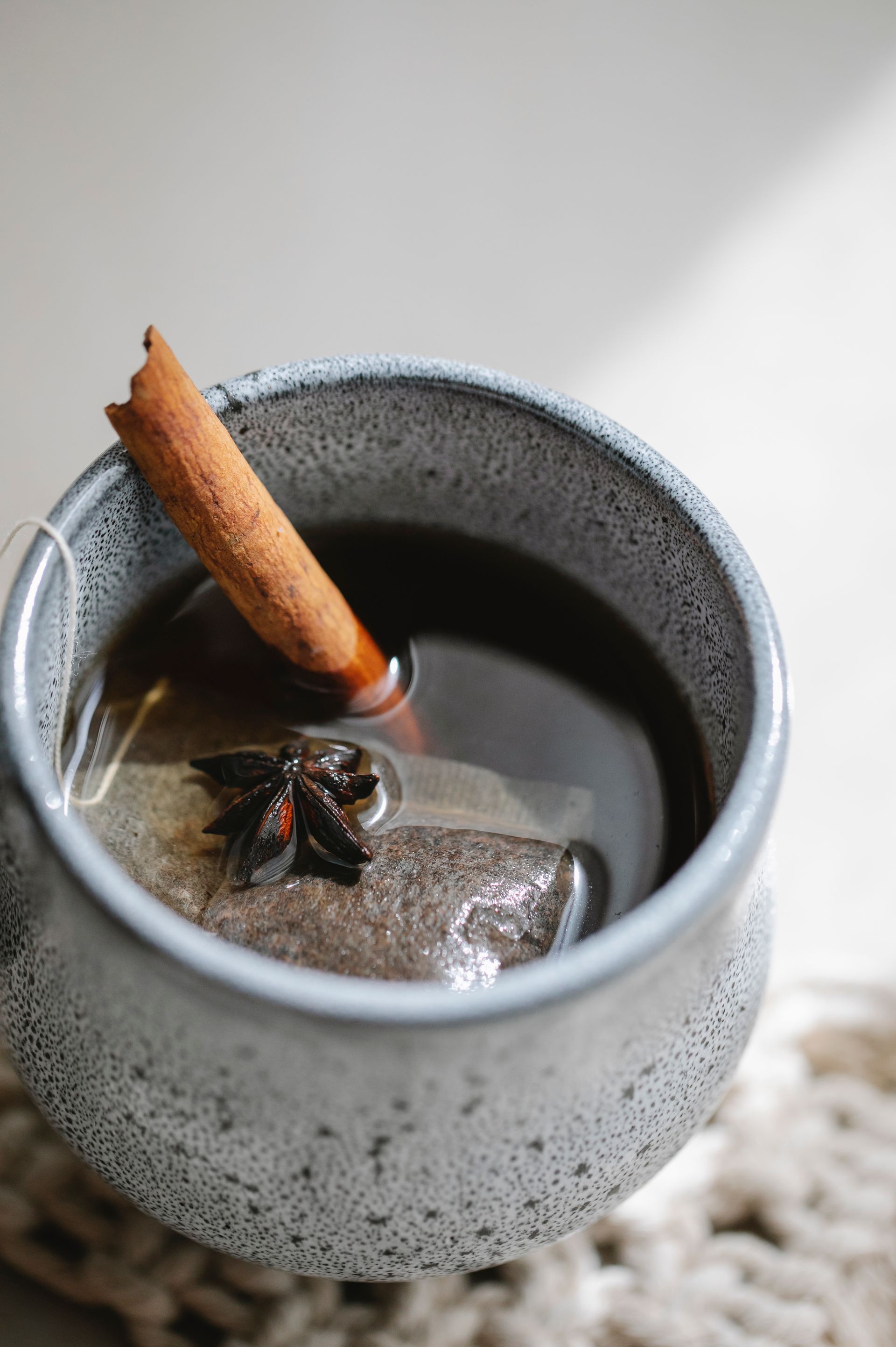 A cup of tea with a cinnamon stick in it.