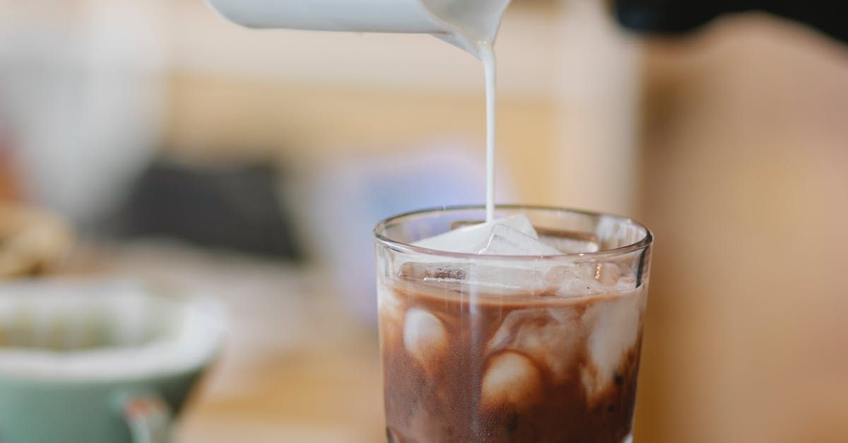 Melk toevoegen aan een glas koffie