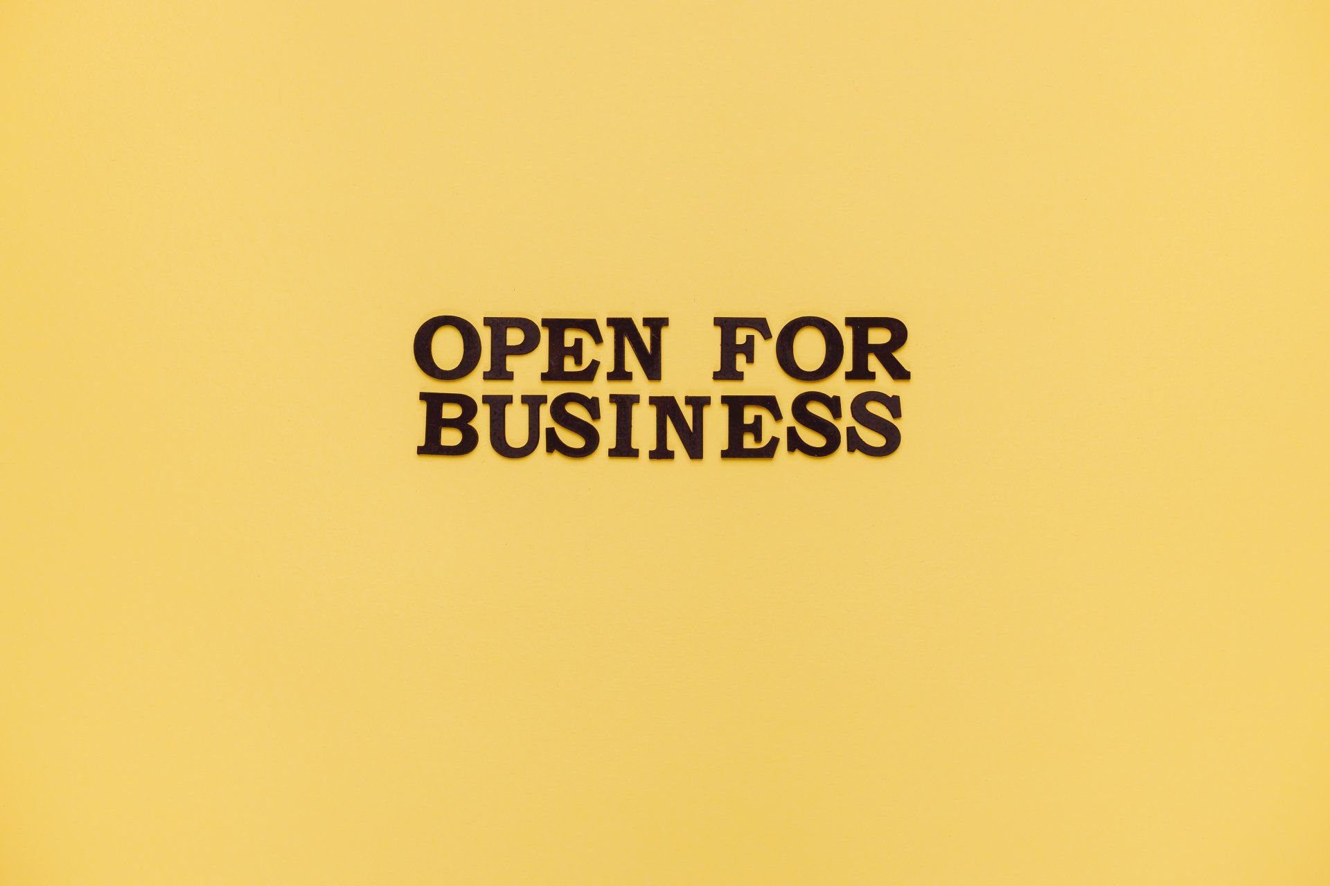 A yellow background with the words `` open for business '' written on it.