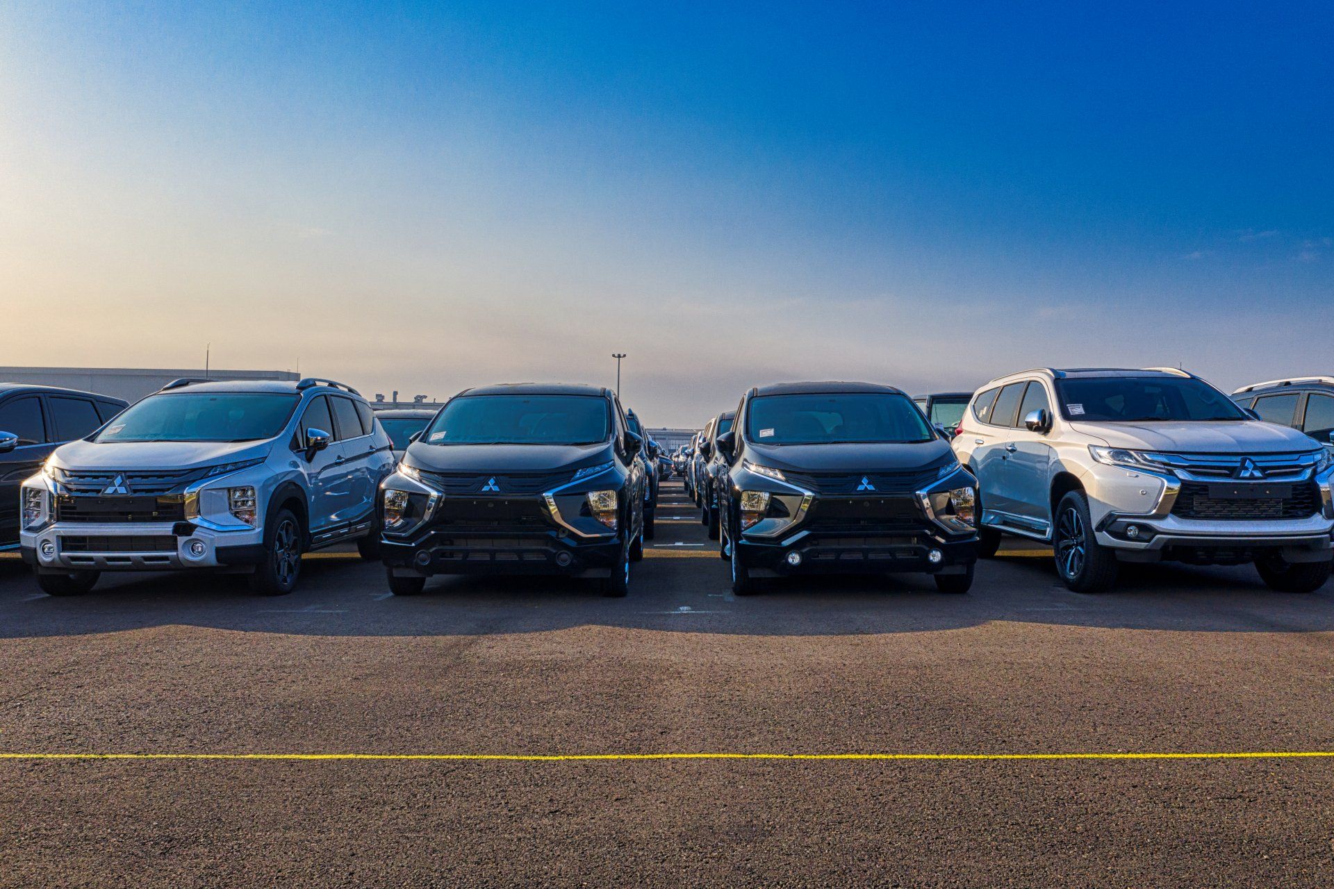 A row of cars are parked in a parking lot.