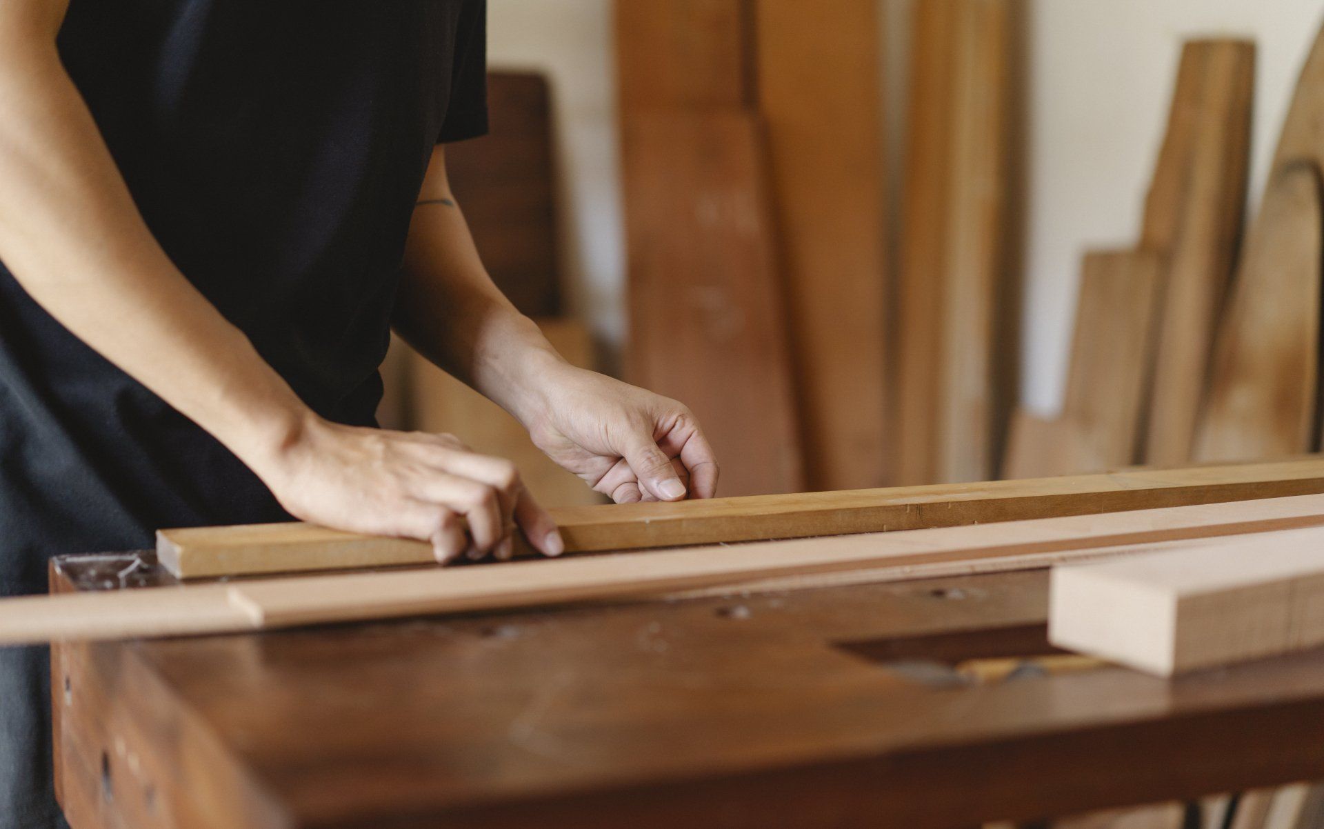 A person is cutting a piece of wood on a table.