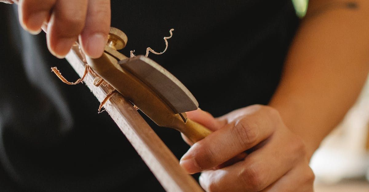 A person is sharpening a piece of wood with a sharpening stone.