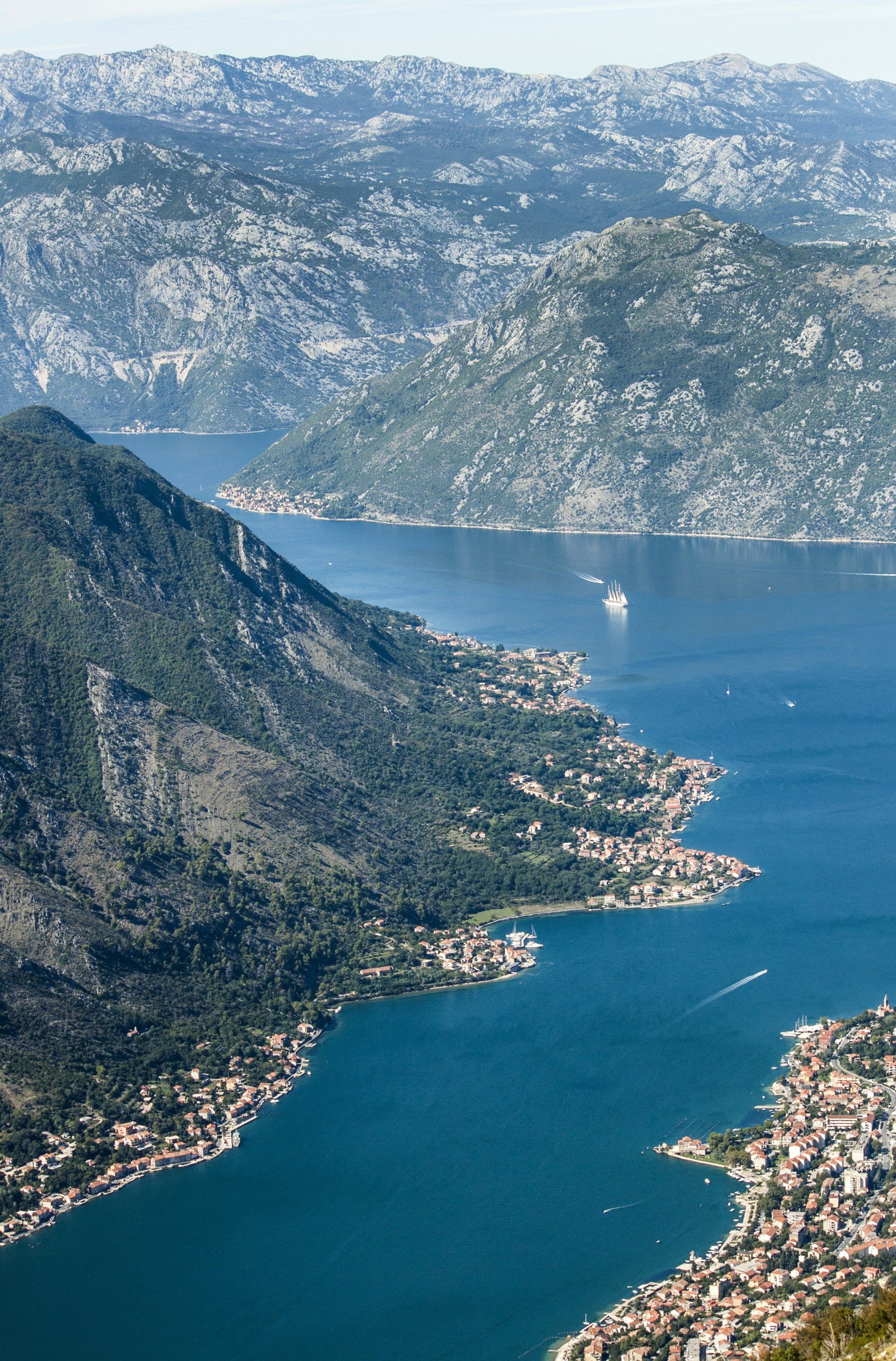 An aerial view of a lake surrounded by mountains and a city.