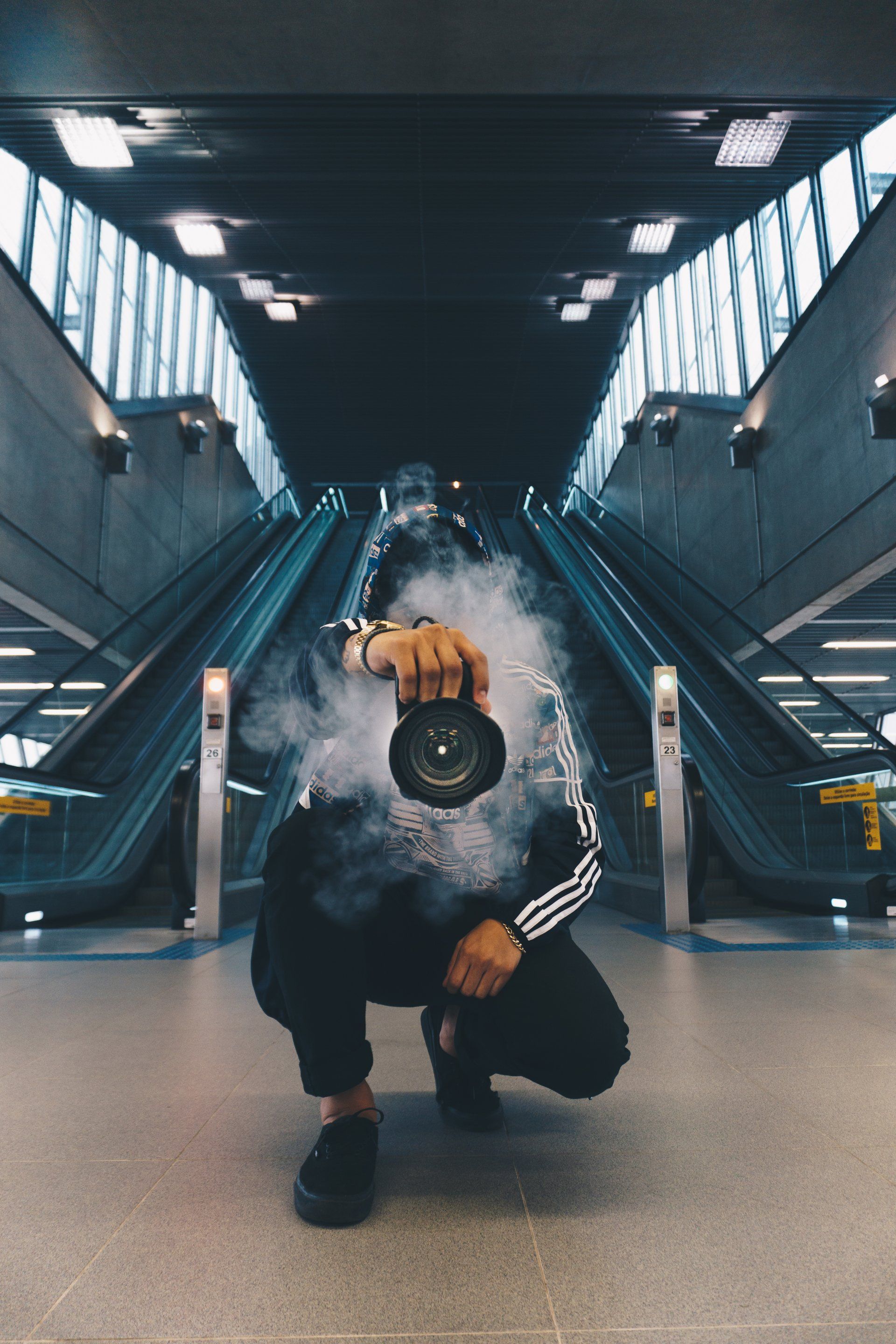 a man is taking a picture of himself in front of an escalator