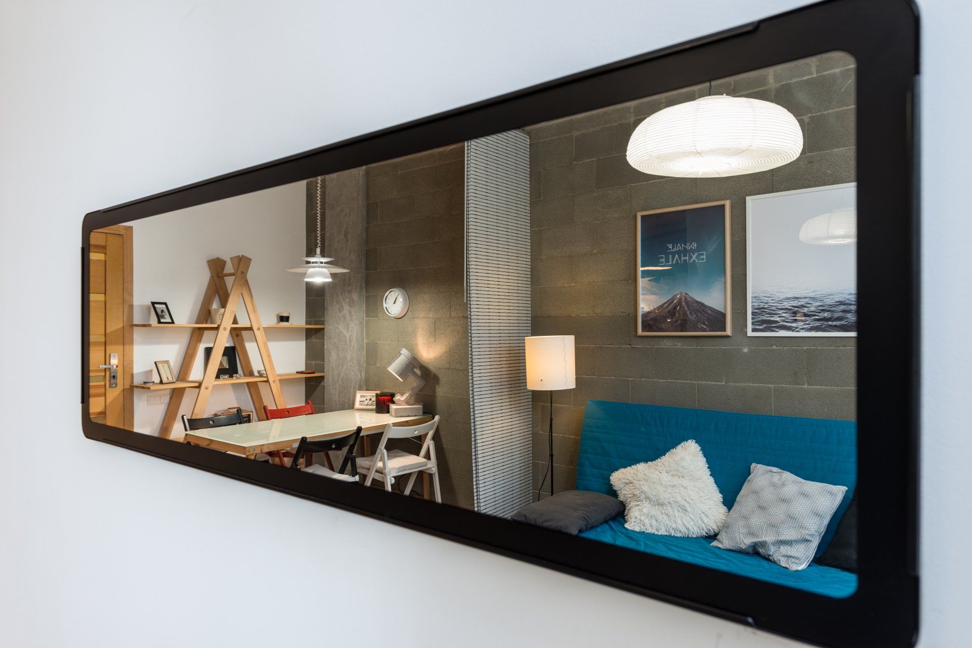 A large mirror is hanging on a wall in a living room.