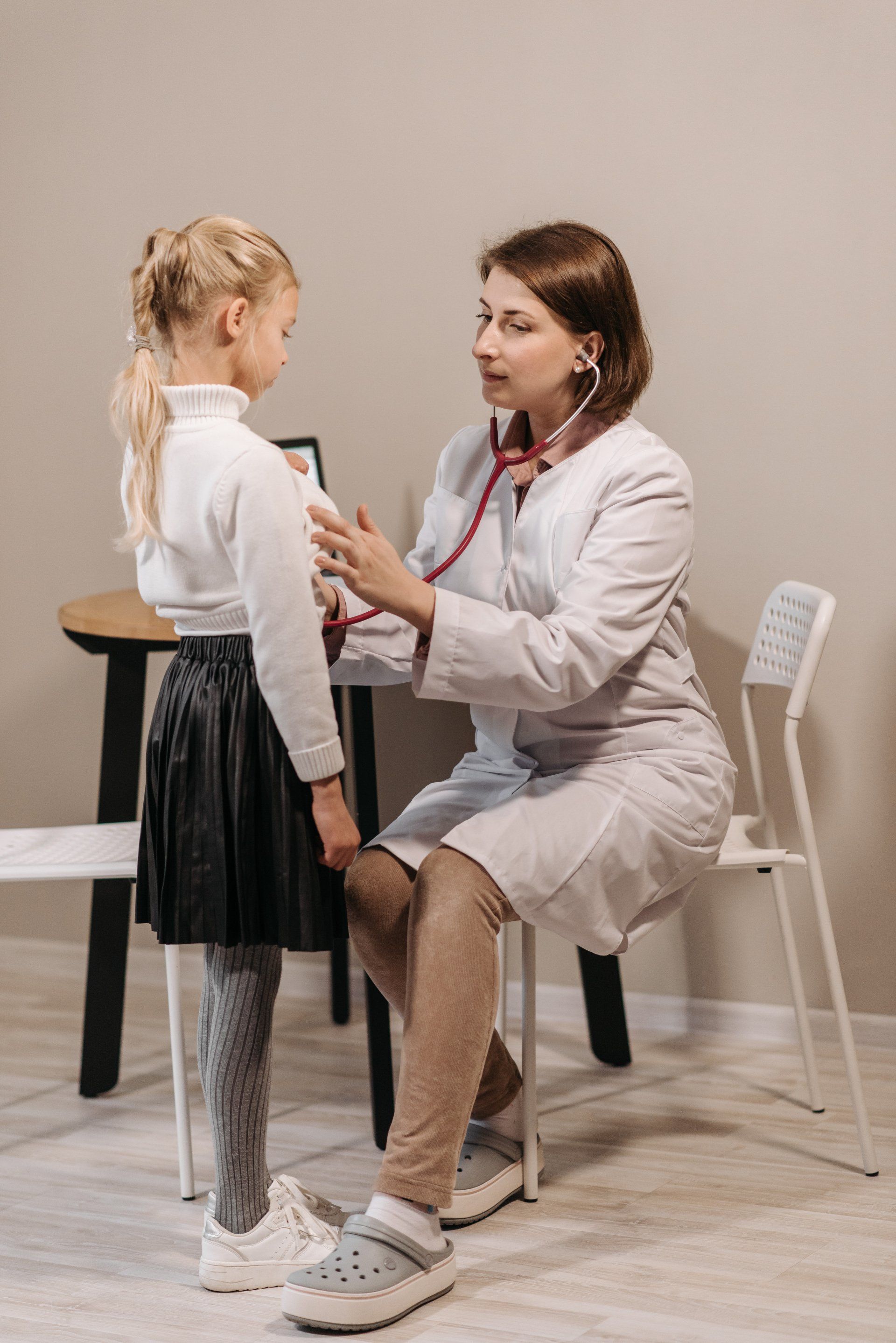 Un medico usa uno stetoscopio per ascoltare il battito cardiaco di una bambina.