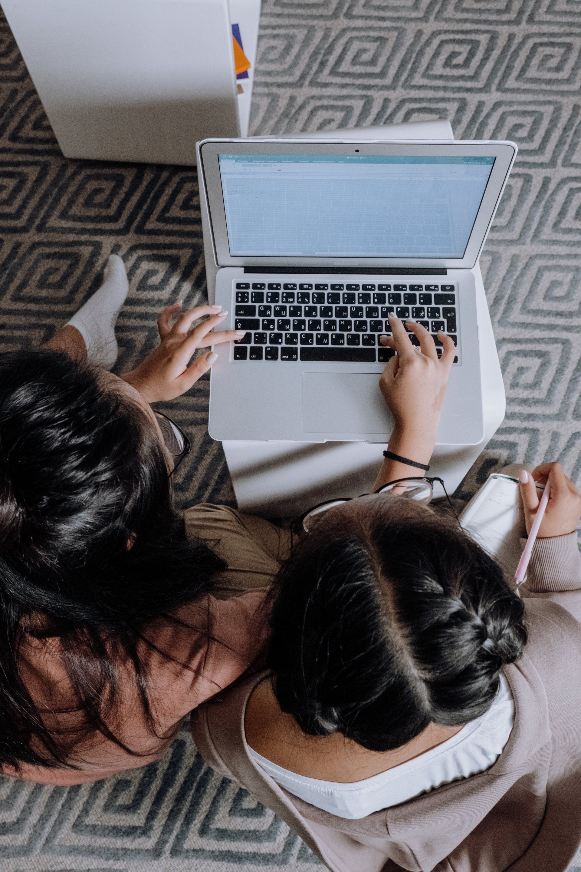 Aerial image of two people typing on laptop.