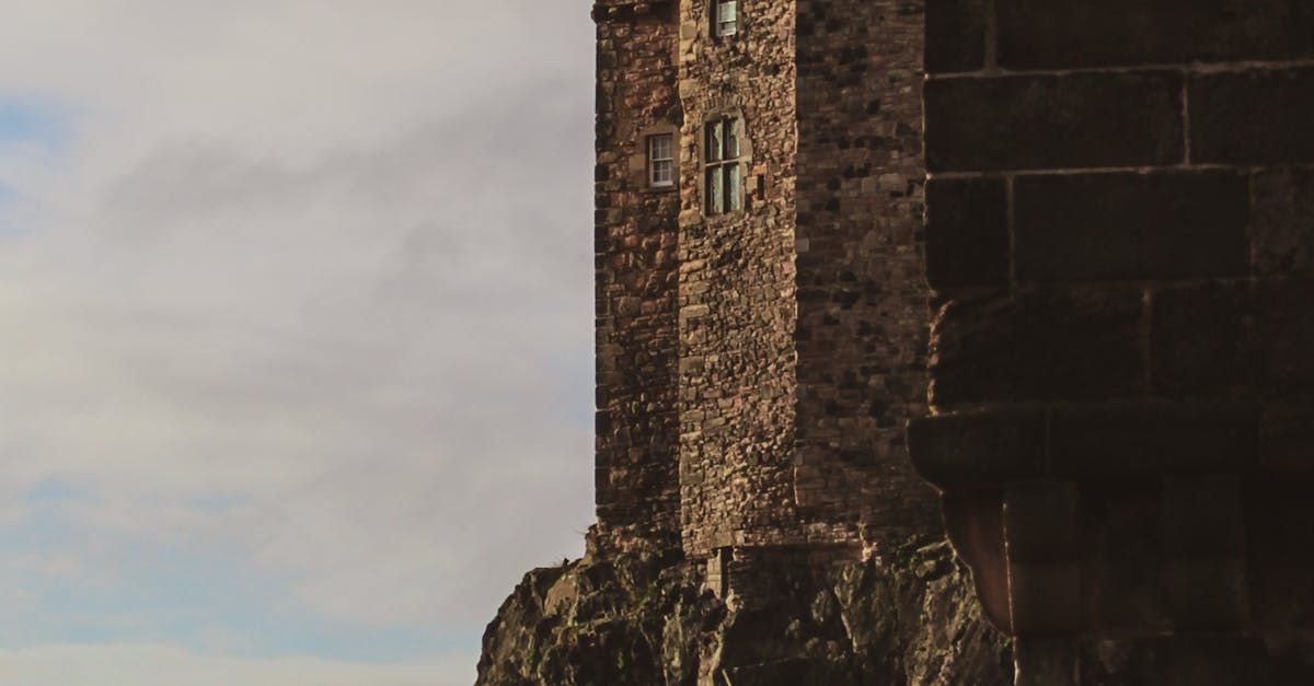 A castle tower is sitting on top of a rocky hill.