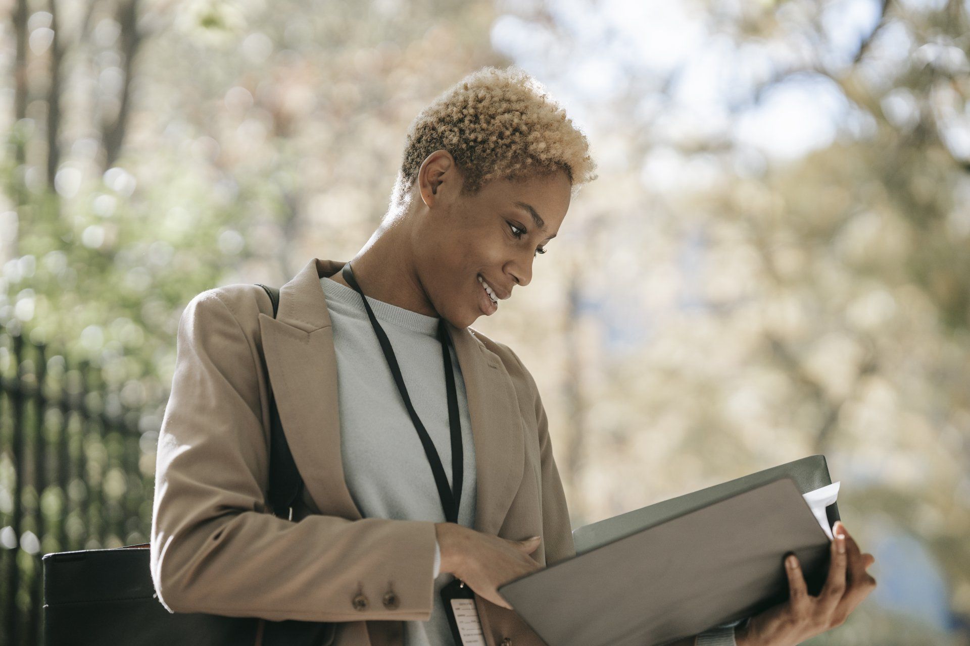 A woman is holding a folder in her hands and smiling.