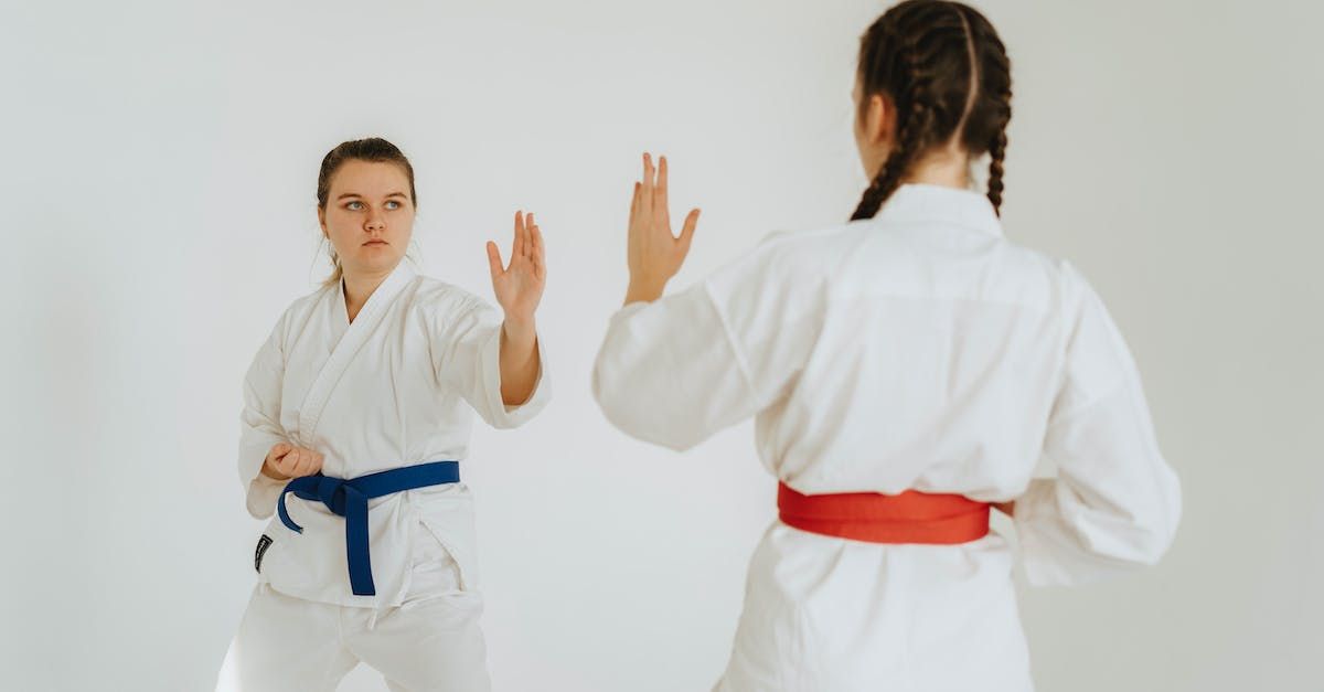 two women are practicing karate together in a gym