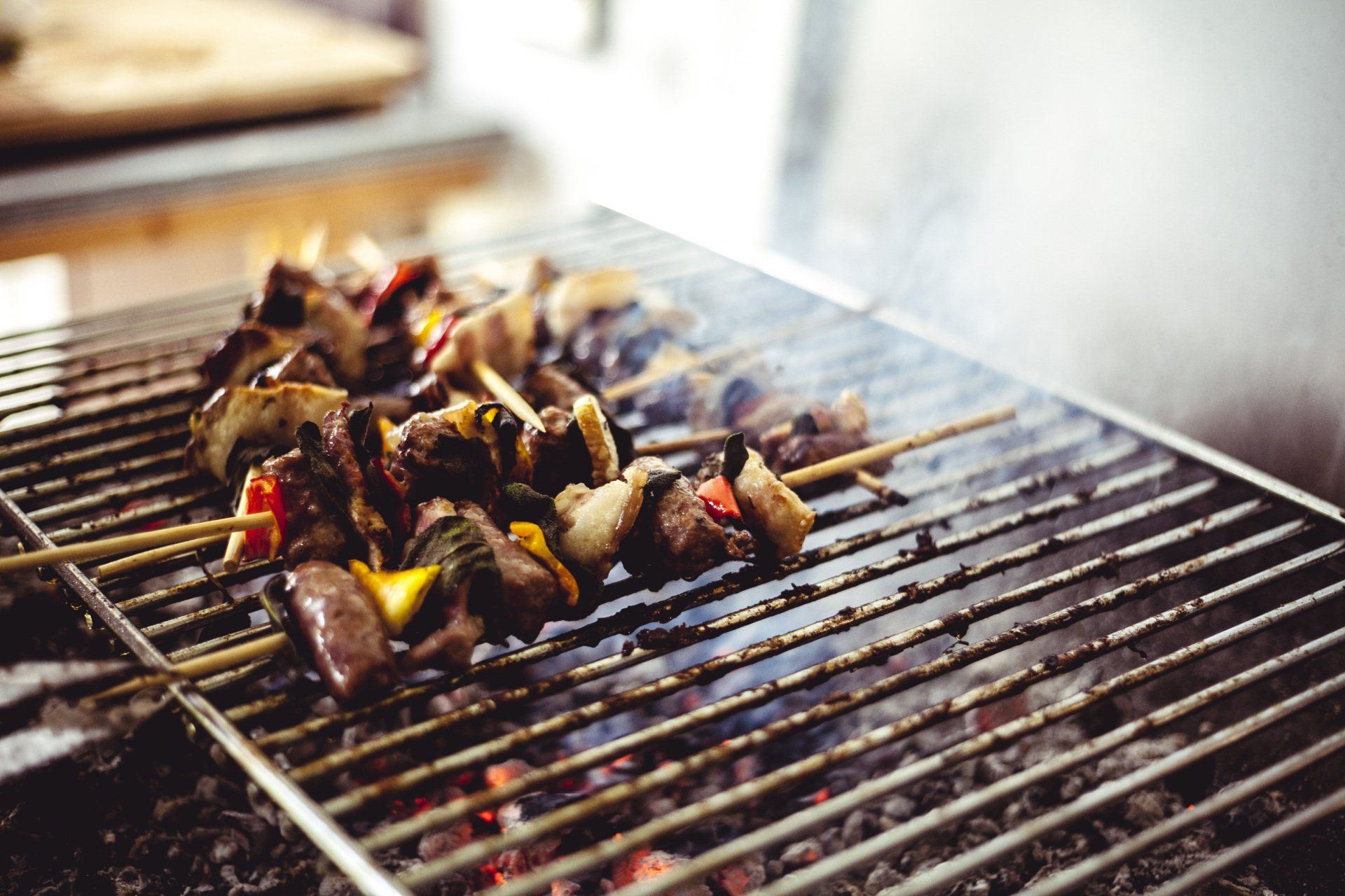 A close up of a grill with meat and vegetables on it.