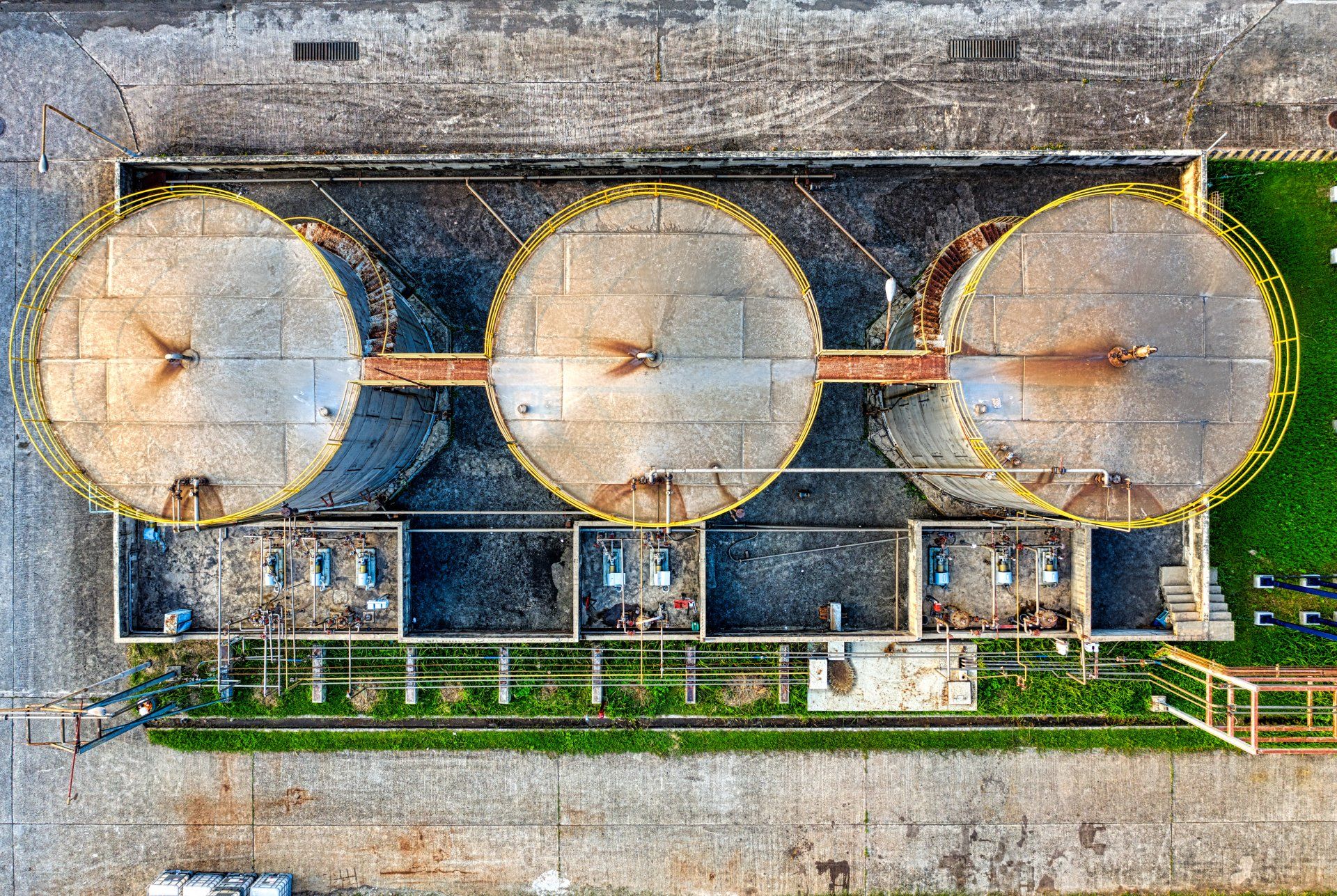 An aerial view of three large tanks in a factory.