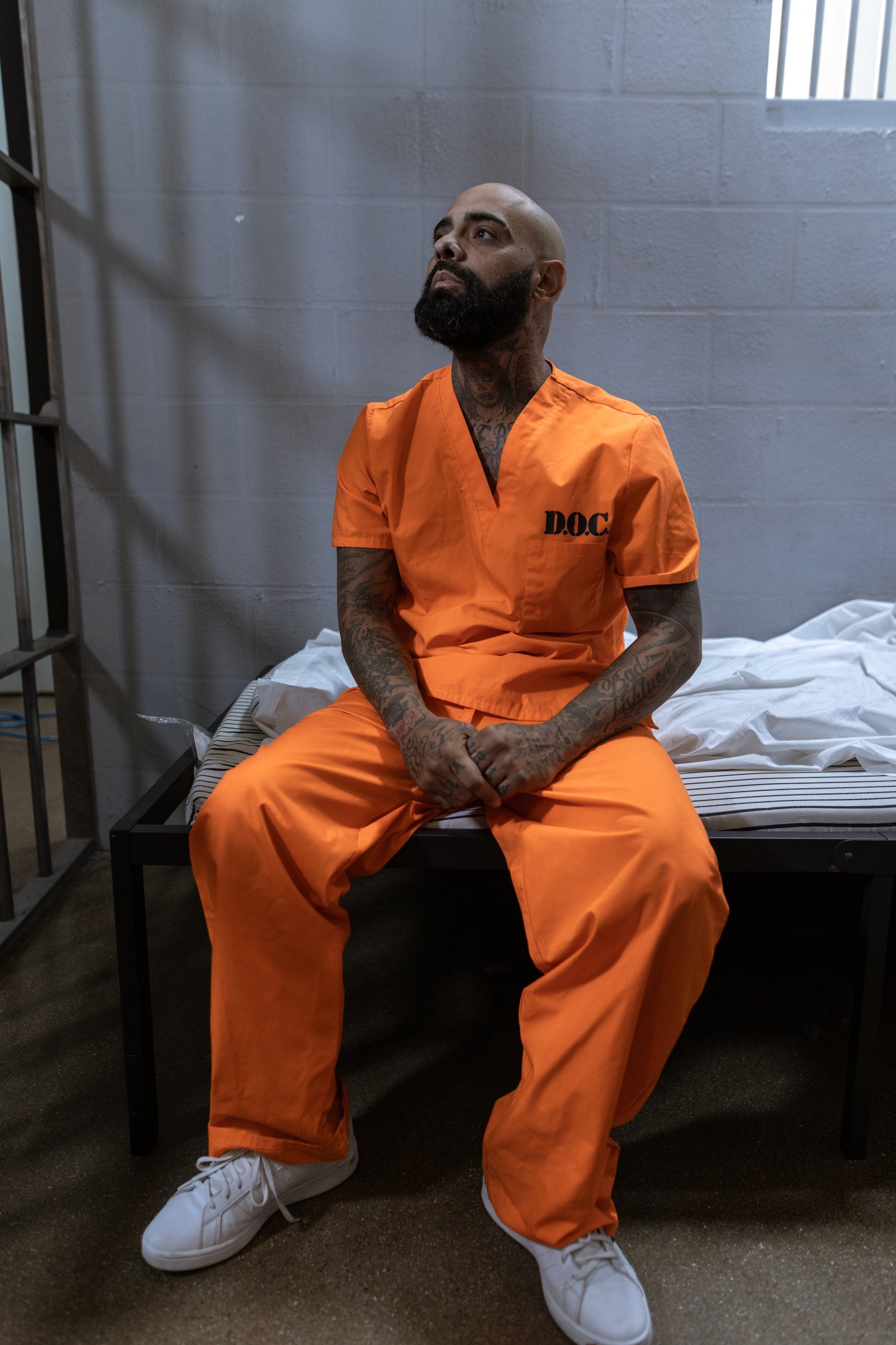 Prisoner sitting in a prison on bunk
