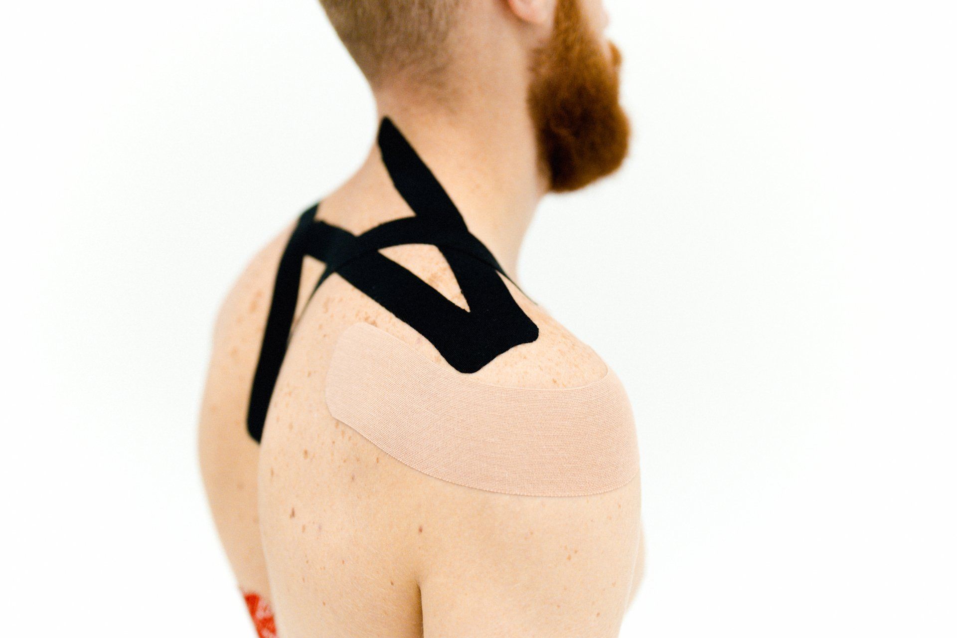 bearded man with kinesio tape on shoulder