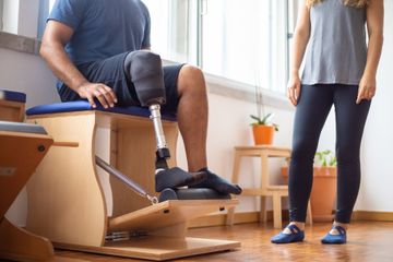 A man with a prosthetic leg is sitting on a chair next to a woman.